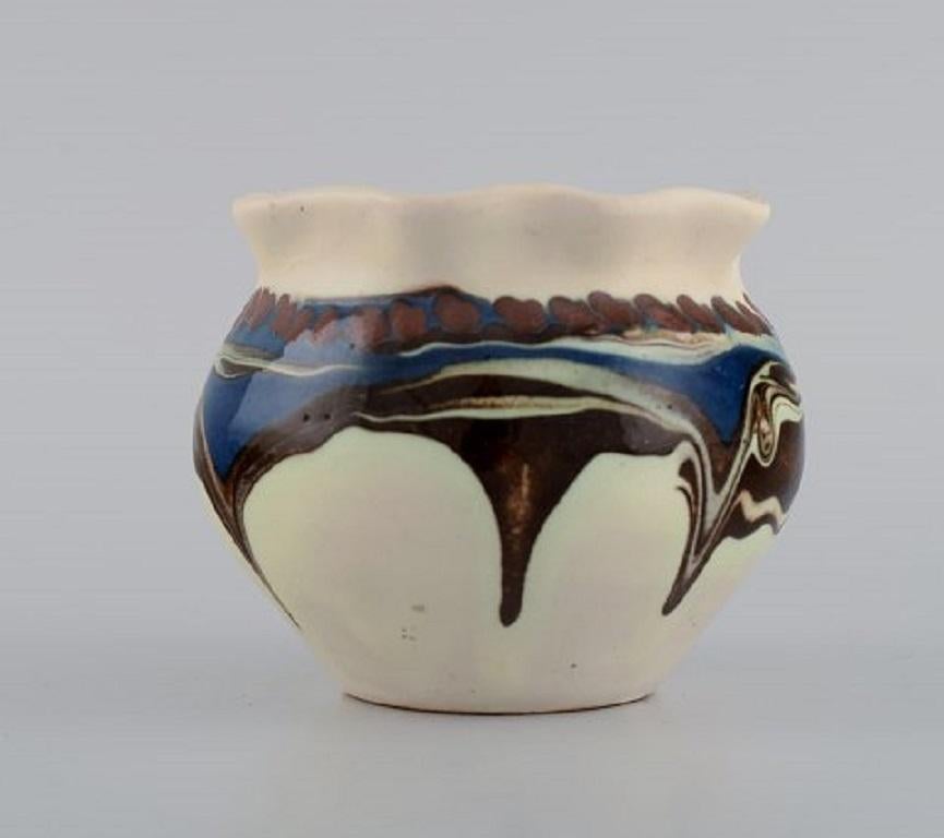 Kähler, Danemark. Vase en grès émaillé au design moderne. Glaçage courant bleu et brun sur fond crème, années 1930-1940.
Mesures : 10.5 x 8,5 cm.
Signé : HAK.
En parfait état.