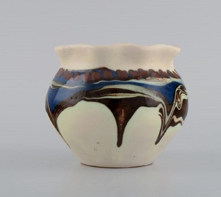 Kähler, Denmark. Glazed stoneware vase in modern design. Blue and brown running glaze on a cream background, 1930s-1940s.
Measures: 10.5 x 8.5 cm.
Signed: HAK.
In excellent condition.