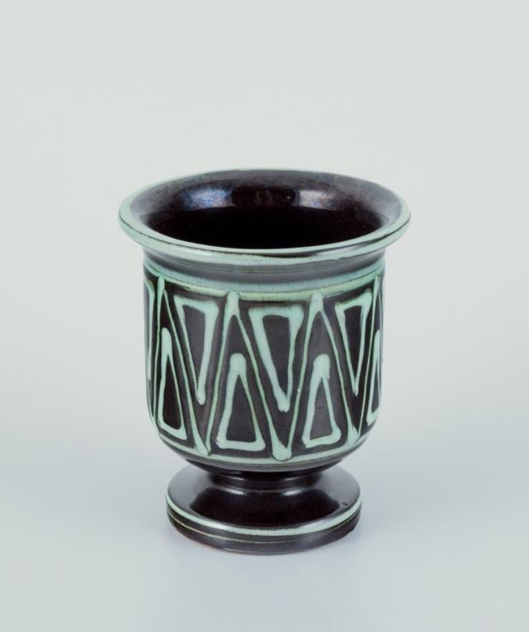 Kähler, Danemark. Petit vase et petit bol avec une anse en forme d'oiseau. Céramique faite à la main. Vase à motif géométrique.
Glaçage dans les tons bleus et verts.
Vers les années 1940.
Tous deux marqués.
En parfait état.
Vase : Hauteur 9,3