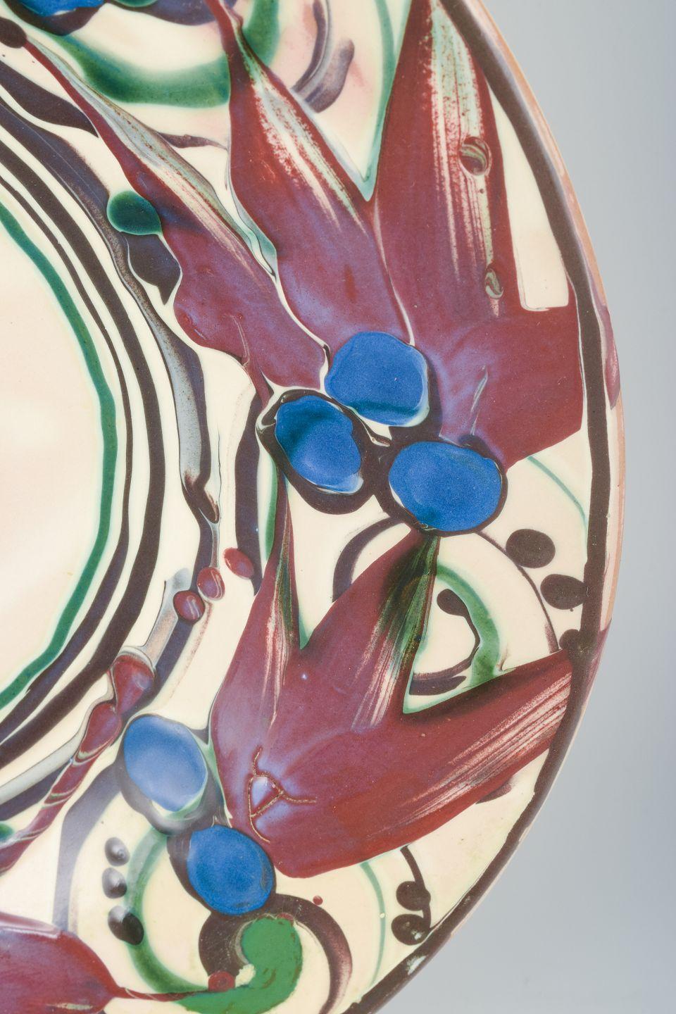 Kähler, Dänemark. Sehr große Keramikschale mit buntem Muster.
Dekoriert in klaren, kräftigen Farben mit blauen Beeren, violetten Blättern und grünen Ranken auf hellem Grund. 
Entlang des Randes befindet sich eine für Kähler-Keramik aus dieser Zeit