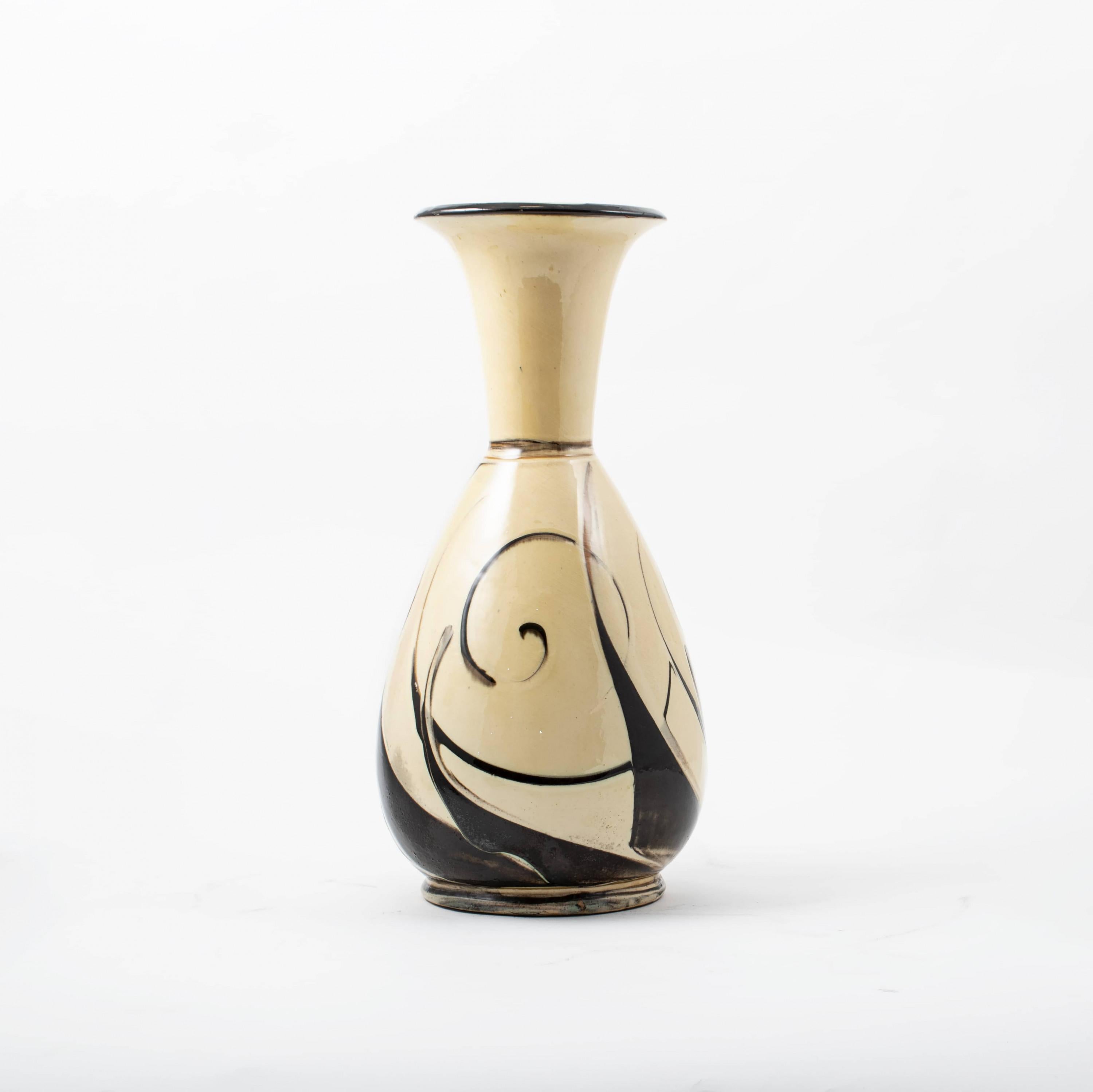 Kähler ceramic vase with black-brown swirling decorations on a cream background.
Signed HAK - Denmark to the base.

Presumably by Julie Kabel for Kähler 1920-1930.