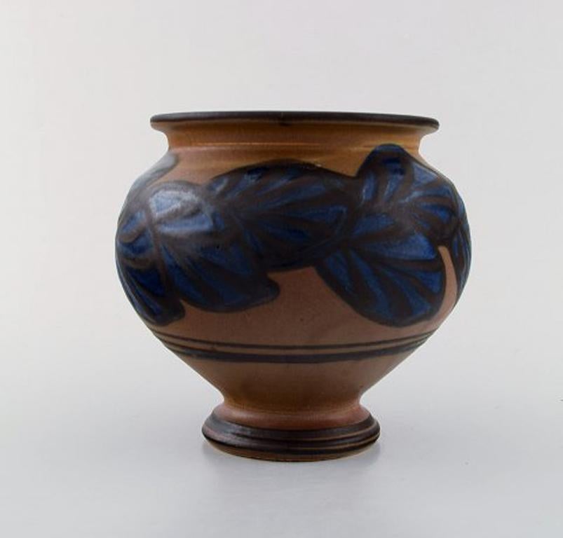 Kähler, HAK, glazed stoneware vase in modern design.
1930s-1940s. Blue leaves on brown background.
Stamped.
Measures: 19 x 13.5 cm.
In very good condition.