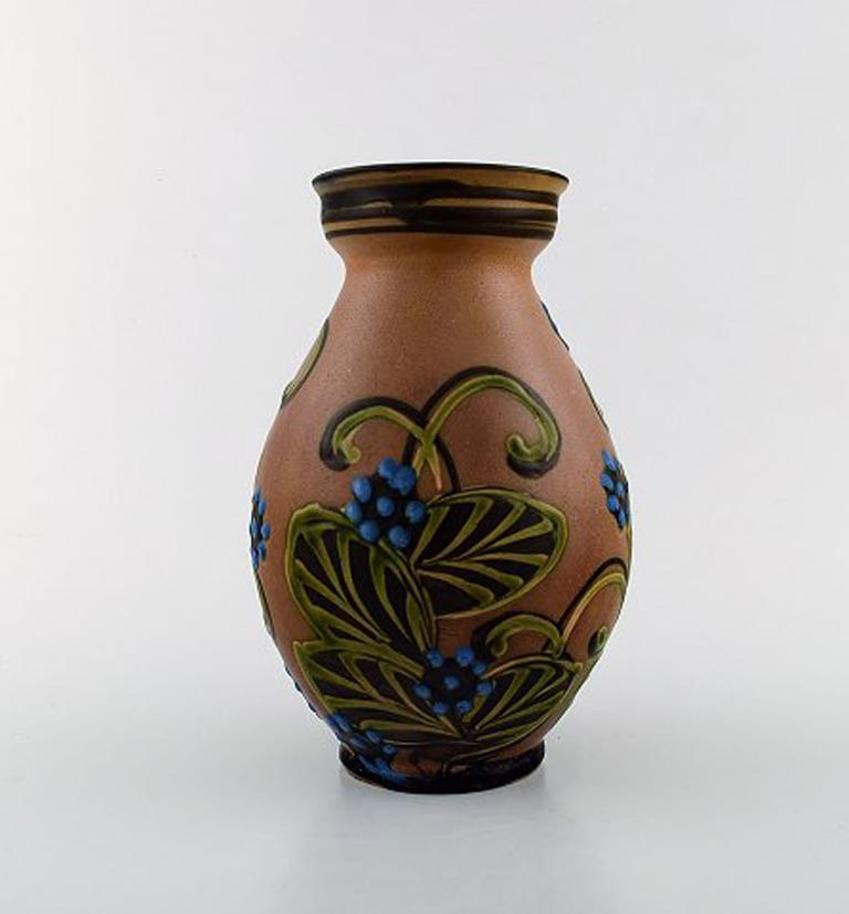 Kähler, HAK, glazed stoneware vase in modern design, 
1930s-1940s. 
Cow Horn technique. Flowers on brown background.
Stamped.
Measures: 20 x 14 cm.
In perfect condition.