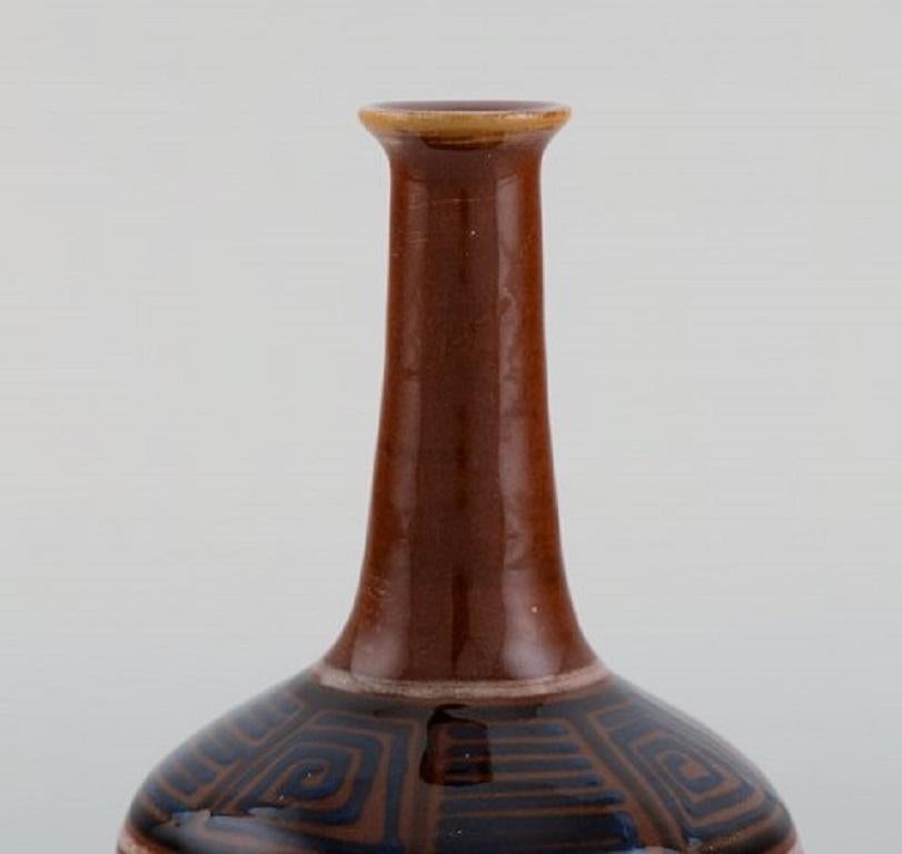 Kähler, HAK. Narrow neck vase in glazed ceramics. Geometric pattern on brown background, 1940s.
Measures: 12 x 9 cm.
Stamped.
In excellent condition.
