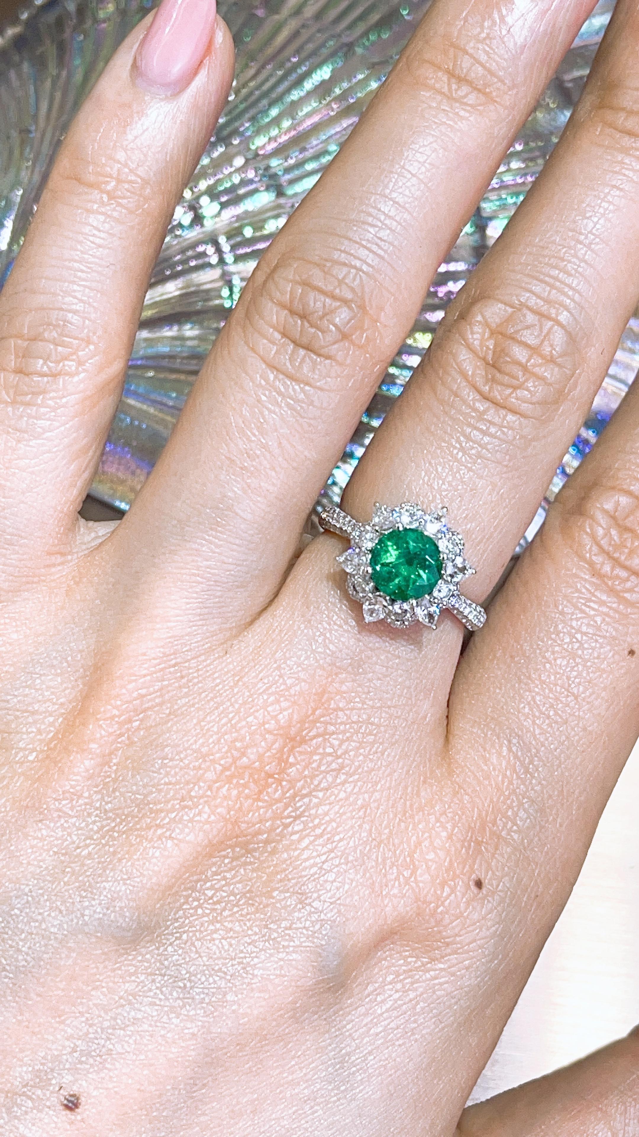 This ring present a 1.3 carat Round cut Emerald set with 12pcs pear shape and round white diamond around the center stone.   finished in 18K white gold, and total white diamond 1.12ct 

Round emerald is quite unusual as most of the emerald cut is in