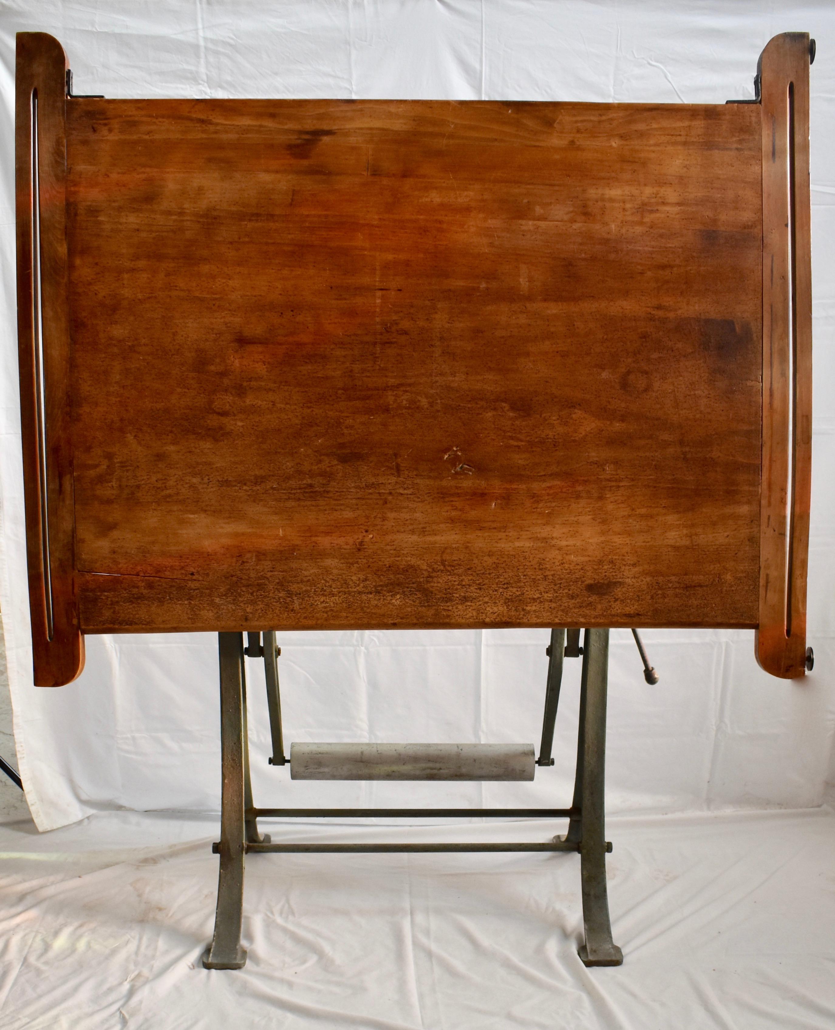 This is a fully adjustable maple drafting table by Kahn Freres of Brussels, Belgium. The cast iron base is in original paint. Nicely worn and mellowed surfaces. Adjusts from 34