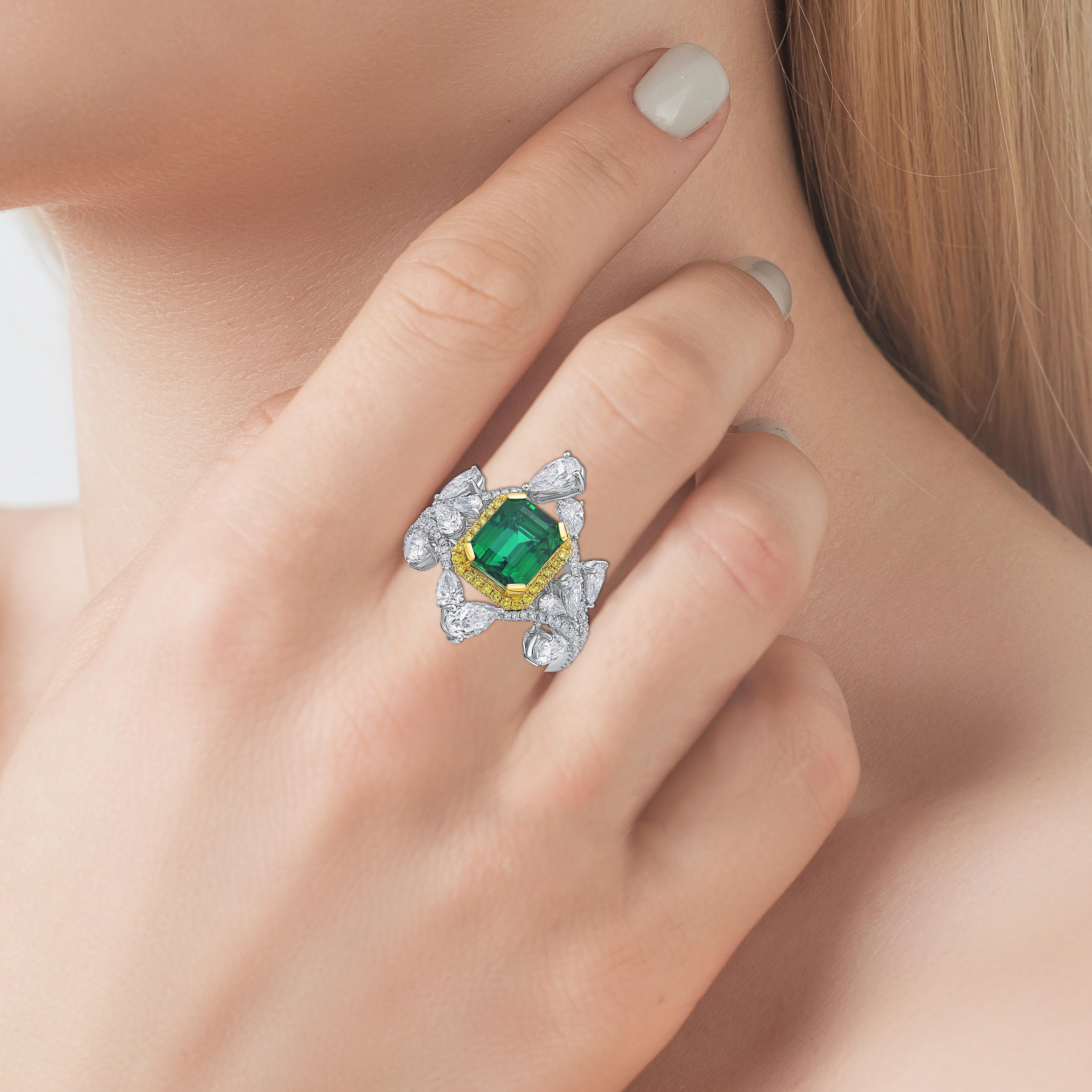This ring present a 2.79 carat emerald shape emerald from Zambia with a halo of yellow diamond, and white diamond, finished in white gold. 

Zambian emeralds are rising in popularity in the gemstone world. And they had a desirable vivid green color.