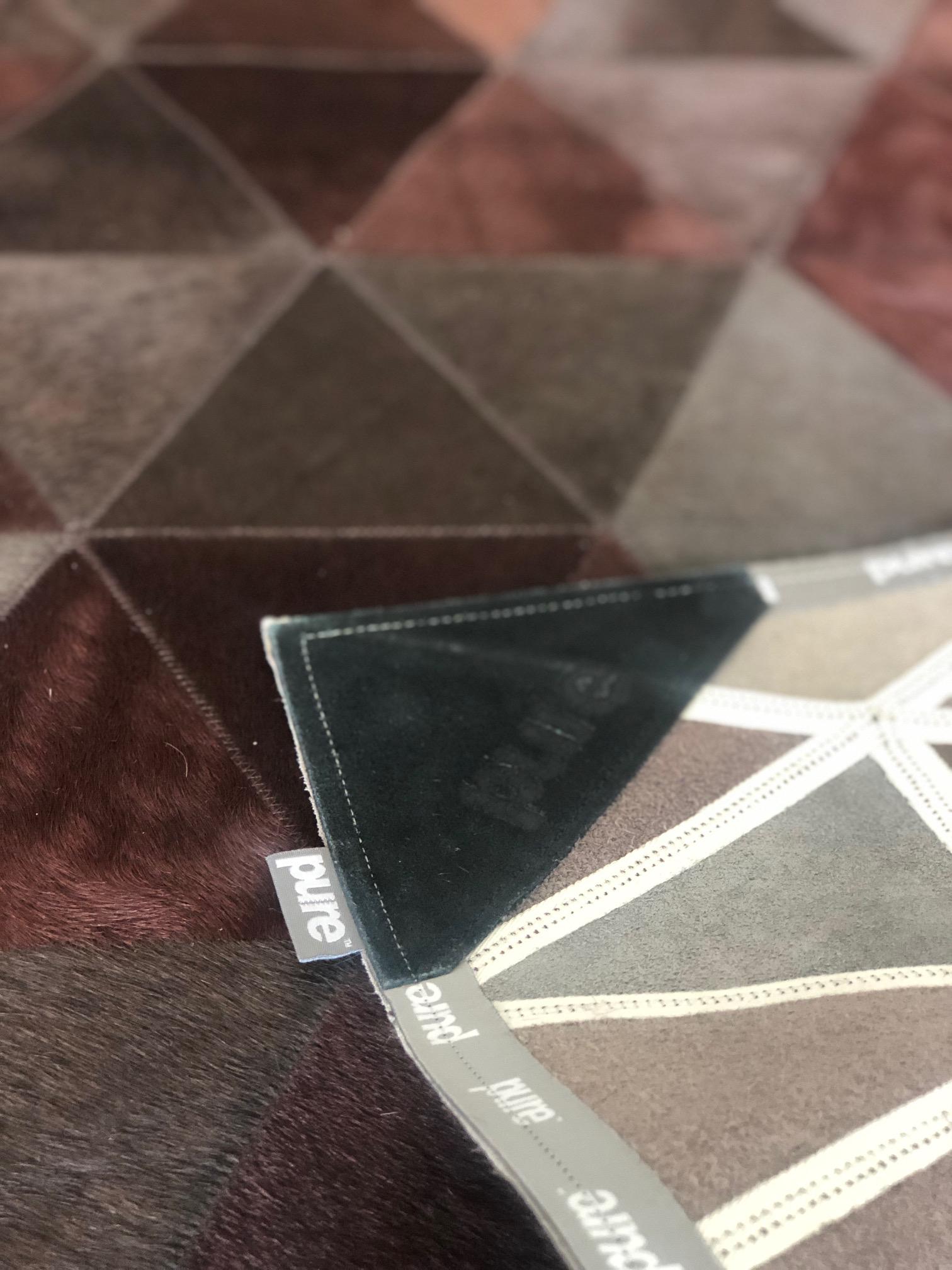 The Kahn cowhide rug showcases an alternating triangle design that offers both order and playfulness. Combining the strength of the pattern and the calm of the natural material, this rug adds a geometric, dynamic, and refined touch to any interior