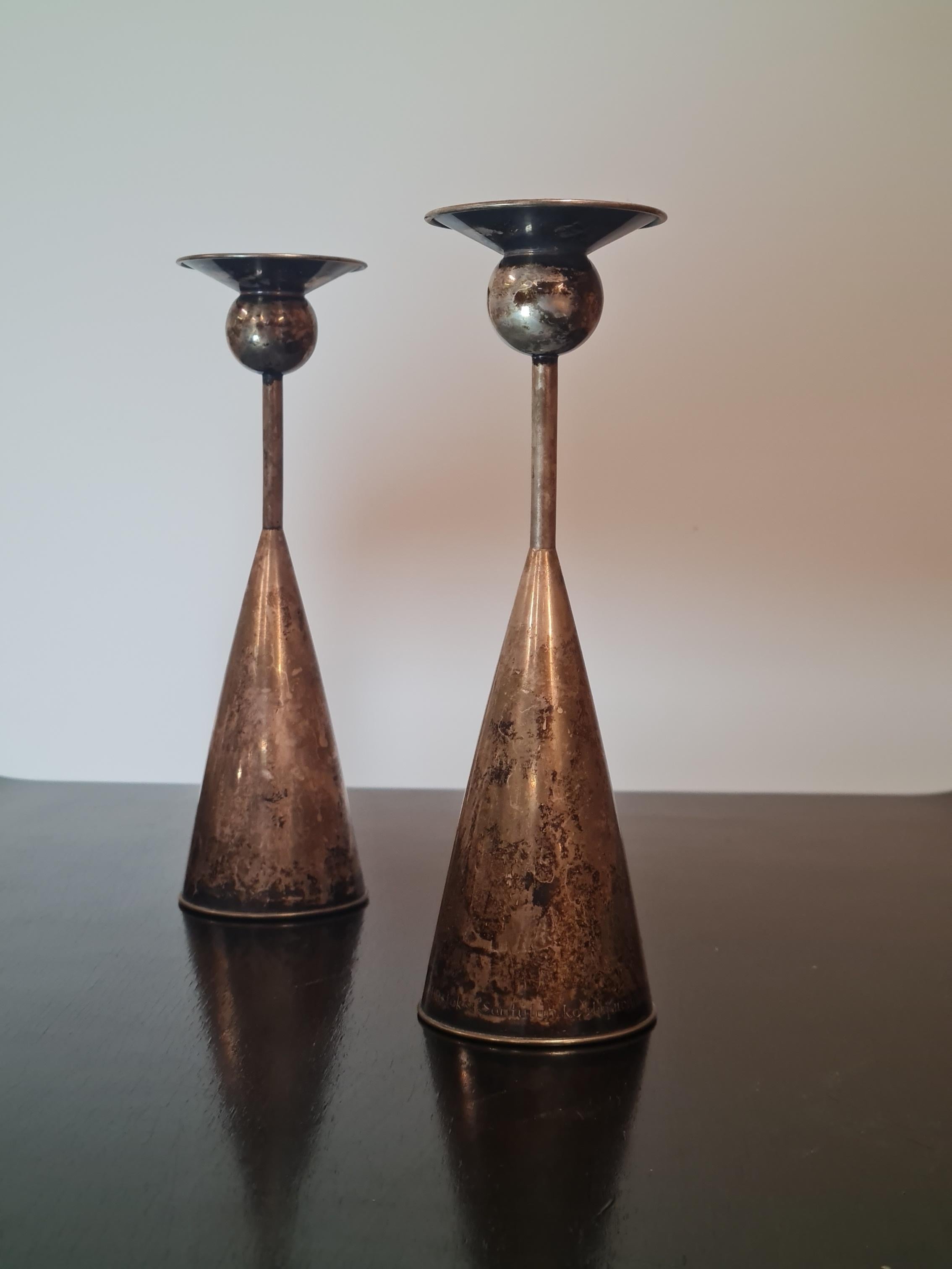 Pair of elegant candle holders desgined by Kai Blomqvist and manufactured by Kultakeskus Oy back in 1965. Both pieces have a series of markings and stamps, which indicate both of them to be solid silver, manufactured by Kultakeskus Oy, and based on