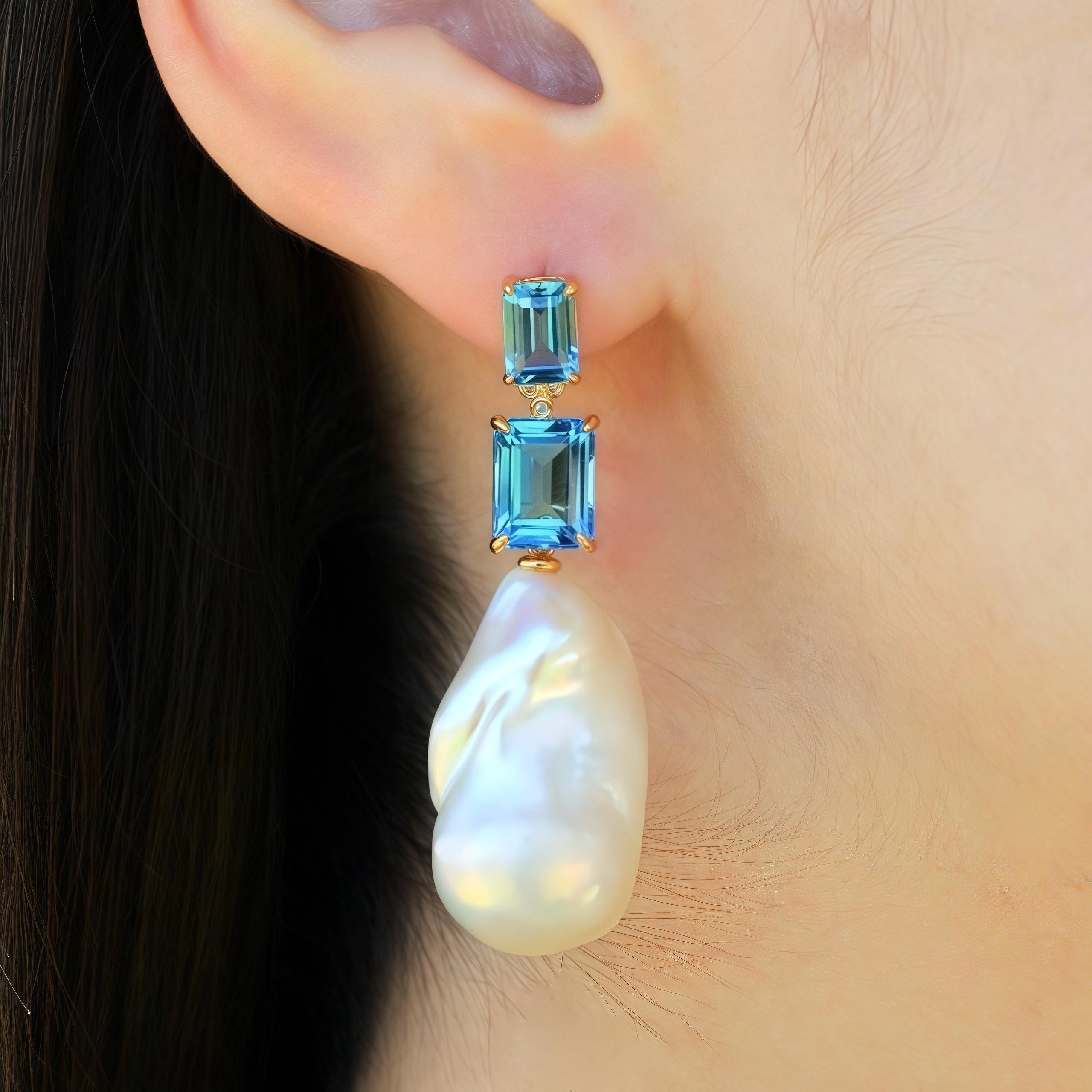 Discover Kai Emerald-Cut 9ct Swiss Blue Topaz Diamond Baroque Pearl Convertible Drop Earrings in 14k yellow gold. These exquisite earrings boast striking emerald-cut Swiss blue topaz gemstones, exuding a mesmerizing azure brilliance akin to a serene
