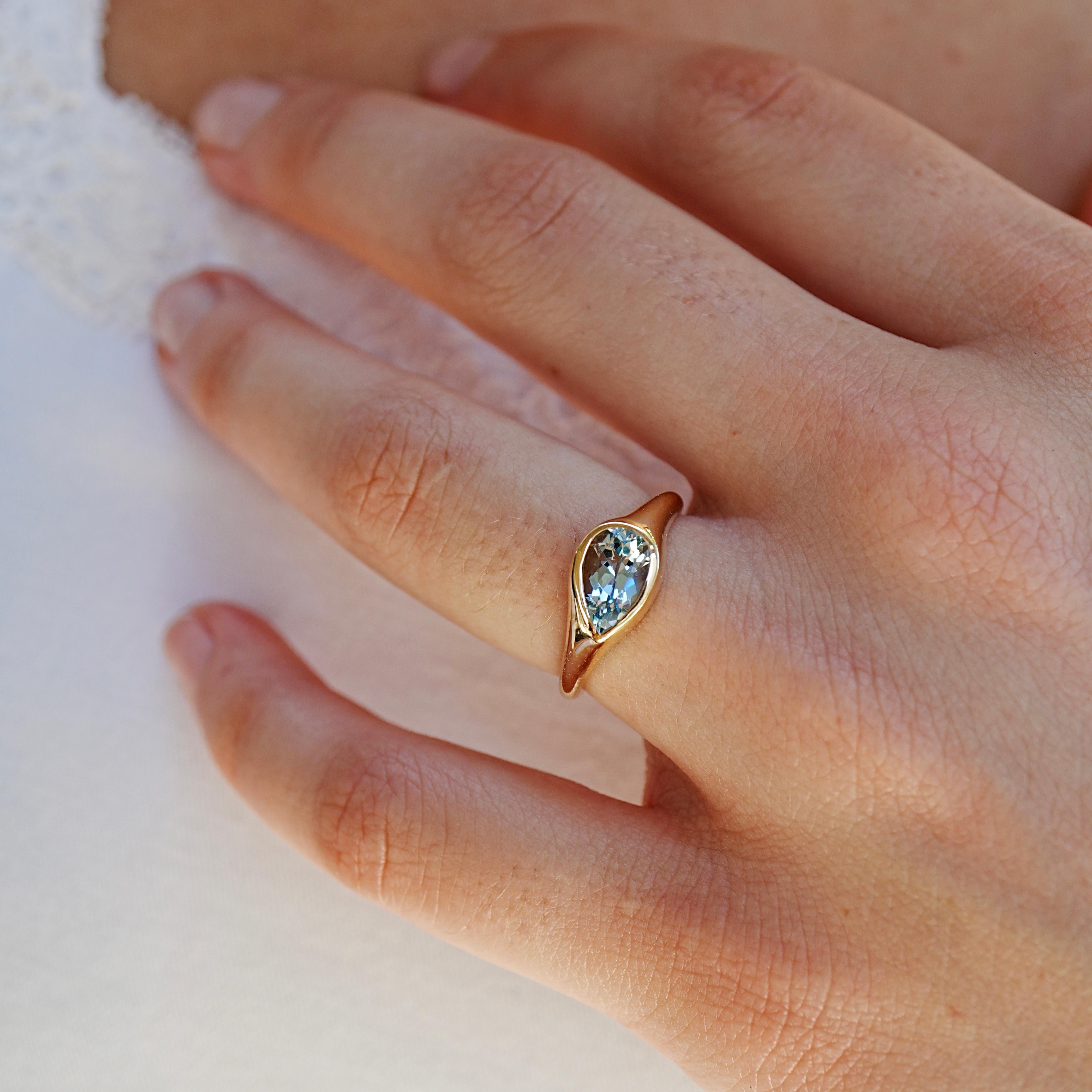 El Anillo Kai Gloria de Aguamarina Pera de 1,00 quilates es una celebración contemporánea de la sencillez y la elegancia. Engarzada en oro amarillo pulido de 14 quilates, la luminosa aguamarina talla pera captura el azul sereno de las aguas