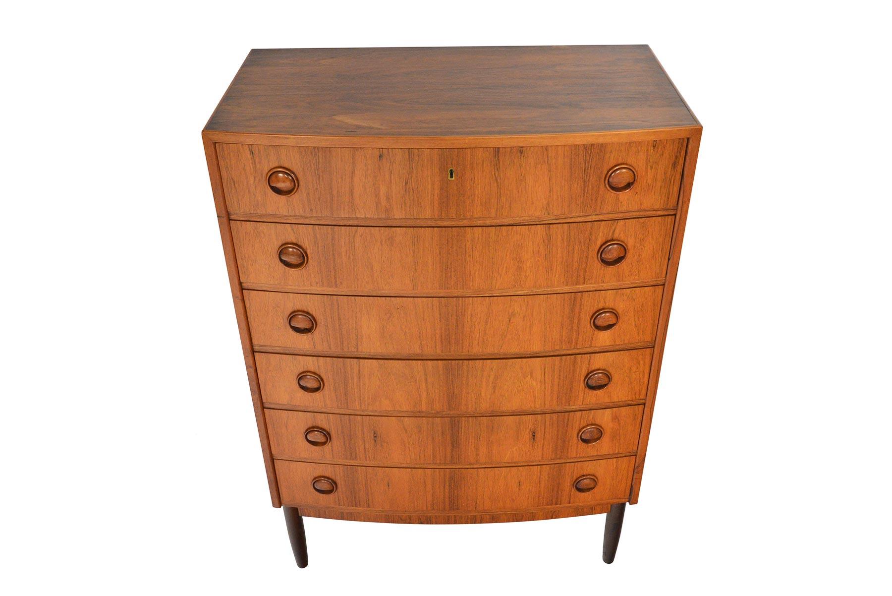 Beautifully bowed, this Danish modern highboy dresser was designed by Kai Kristiansen in the 1960s. Crafted in Brazilian rosewood, this piece offers exceptional joinery and distinguished carved round drawer pulls. In excellent original condition.
  