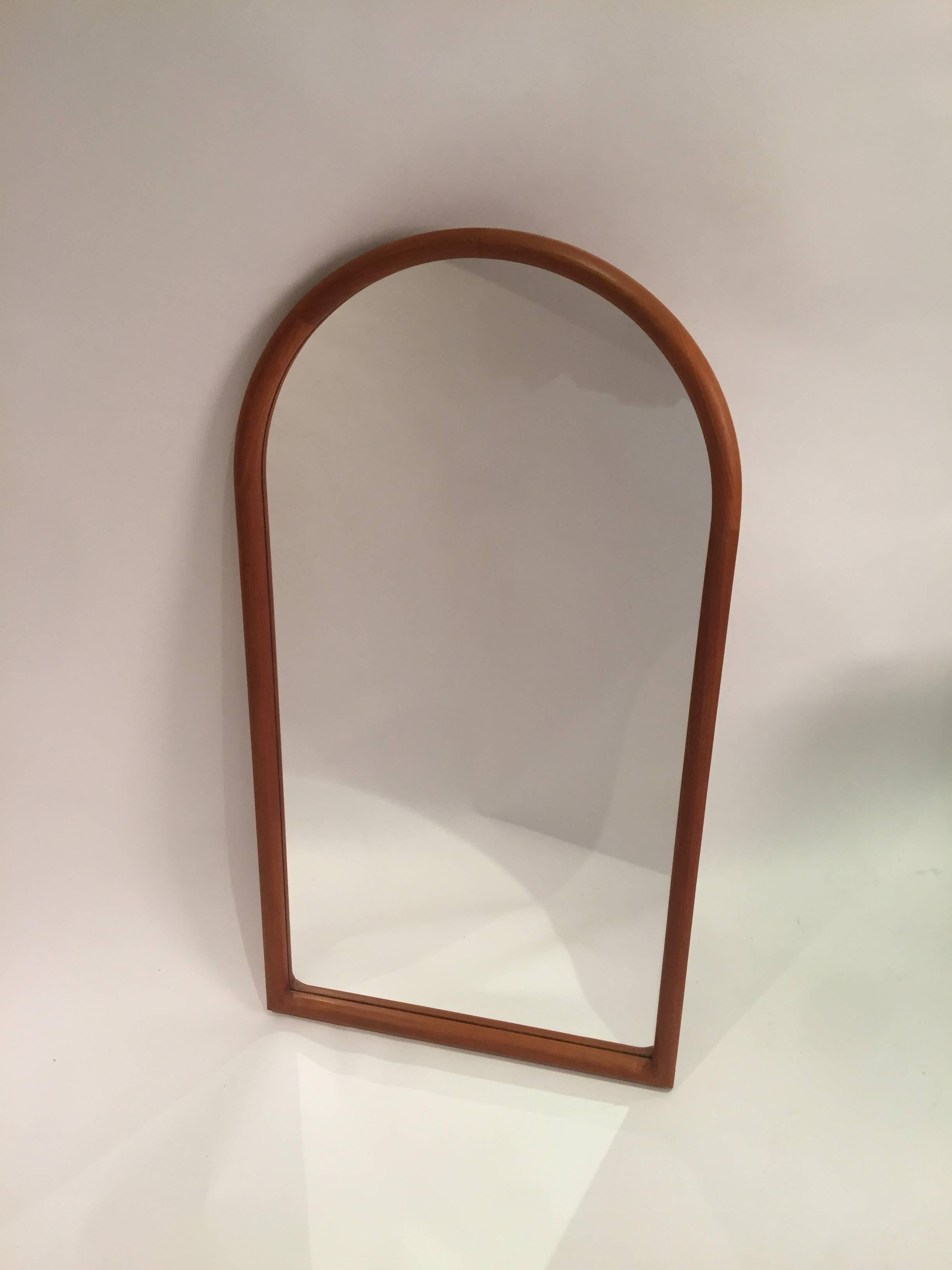 Simple sleek and classic mirror by Kai Kristiansen with an arched top. Wall hanging mirror features a rounded edge frame with dovetailed corners and curved top.
   