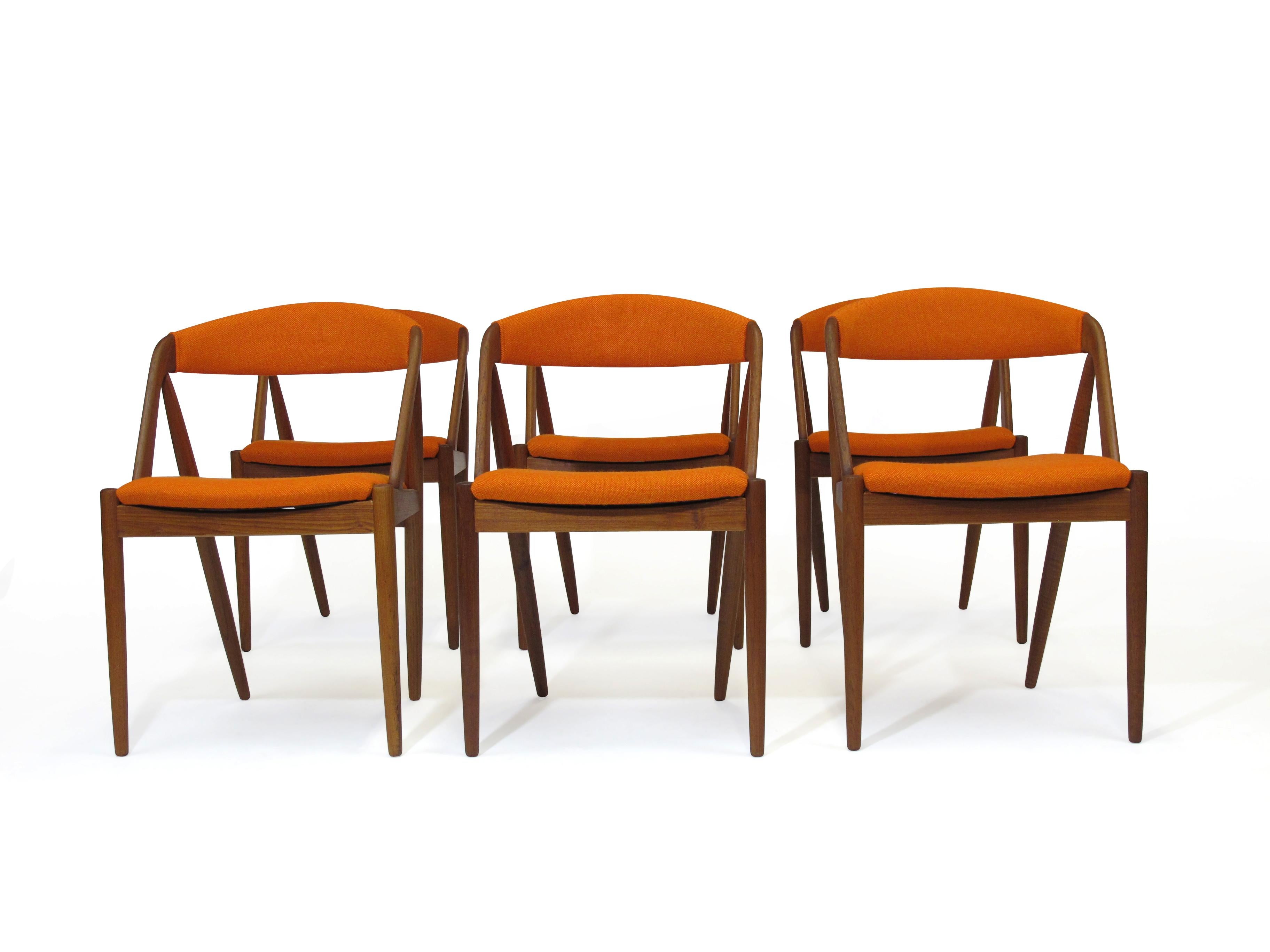 Six Model 31 curved back dining chair designed by Kai Kristiansen. This is a very comfortable chair design with excellent back support. Seat frame constructed of wood frame with rubber strap supports Newly upholstered in orange Hallingdal wool.