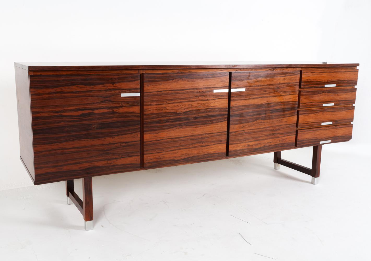 Questa splendida credenza in legno di palissandro è stata disegnata da Kai Kristiansen negli anni Sessanta. Il design di questa credenza crea un'immagine imponente con linee pulite e un profilo elegante. Poggiato su gambe a slitta, con accenti in
