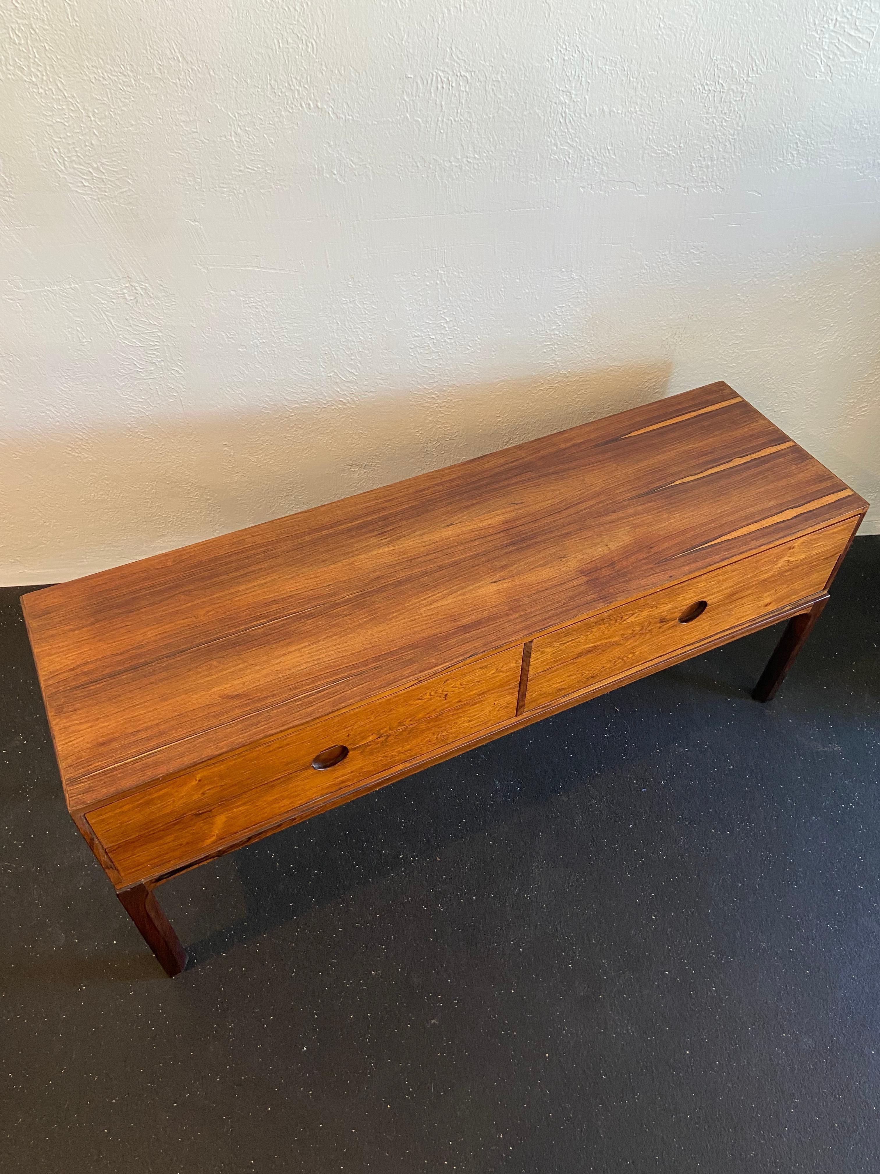 Kai Kristiansen diminutive rosewood chest of drawers. Four drawers with circular cut out pulls. Some faint wear to top (please refer to photos). 

Would work well in a variety of interiors such as modern, mid century modern, Hollywood regency,