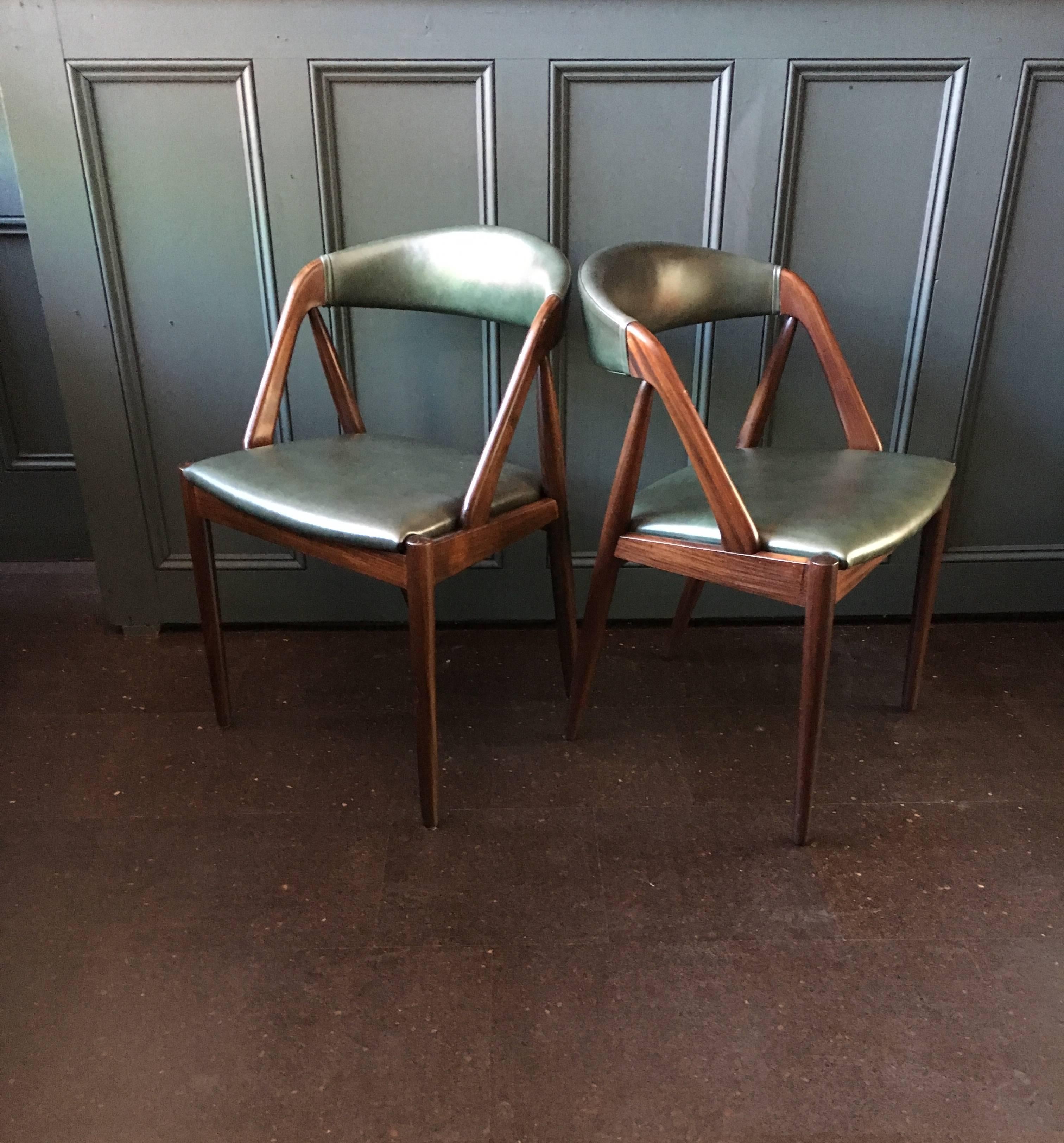 Set of four, professionally reupholstered in deep green Italian leather, Kai Kristiansen model 31 chairs. Repolished very dark teak frames. Produced by Schou Andersen, Denmark, 1960s.
 Insured worldwide shipping 