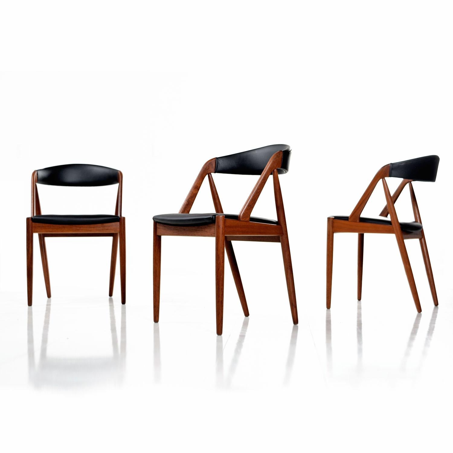 Stunning set of eight, circa 1960s Kai Kristiansen Danish teak chairs model #31 for Schou Andersen. Unmistakable form evidences Kristiansen’s genius. Each chair stands as a work of art, captivating the eye from every angle. Comfortable as they are