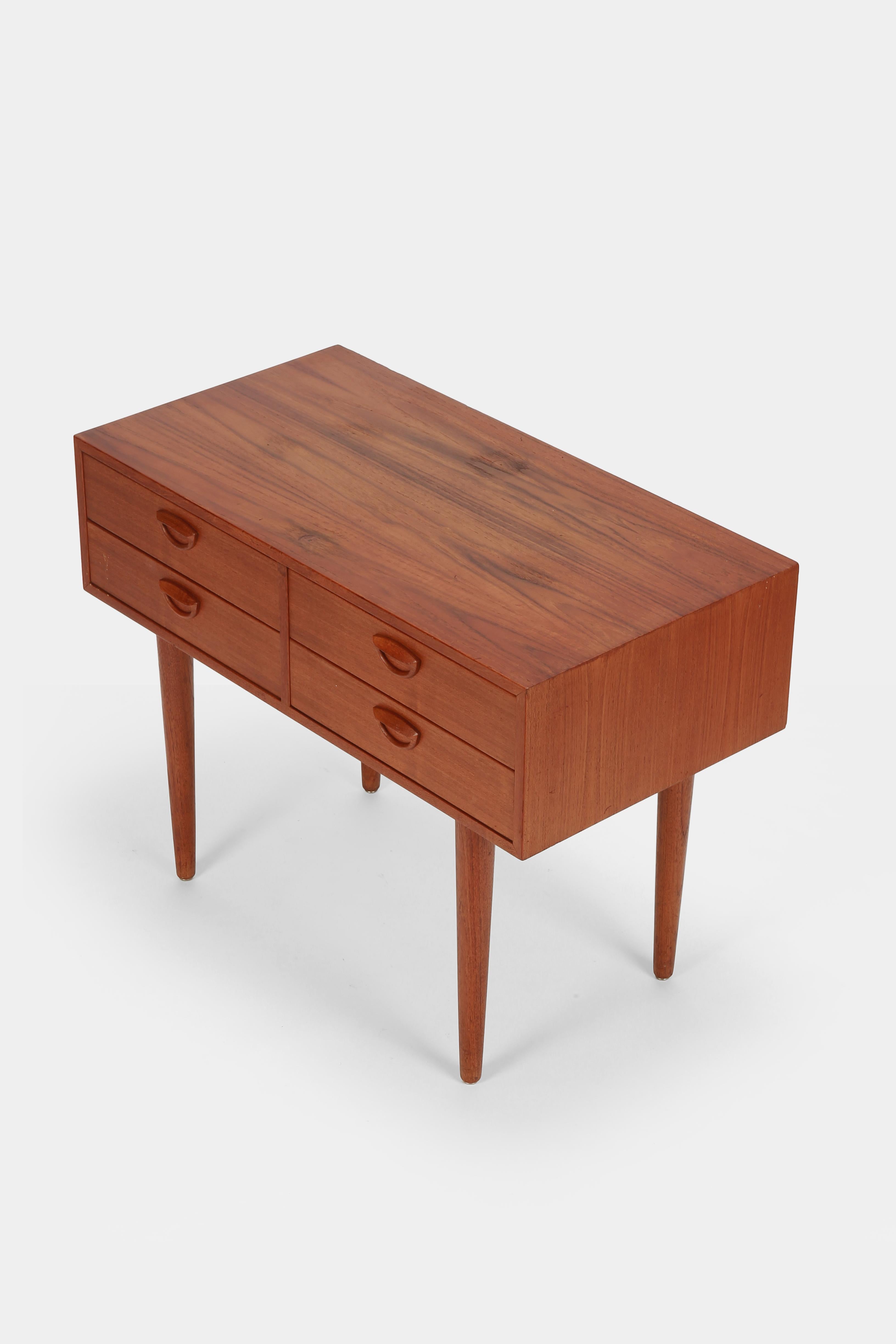 Mini sideboard by Danish designer Kai Kristiansen for Feldballes Møbelfabrik, designed and manufactured in the early 1960s. Made of teak with solid legs and handmade solid handles, the interior of the drawers is made of birch wood. Slight signs of