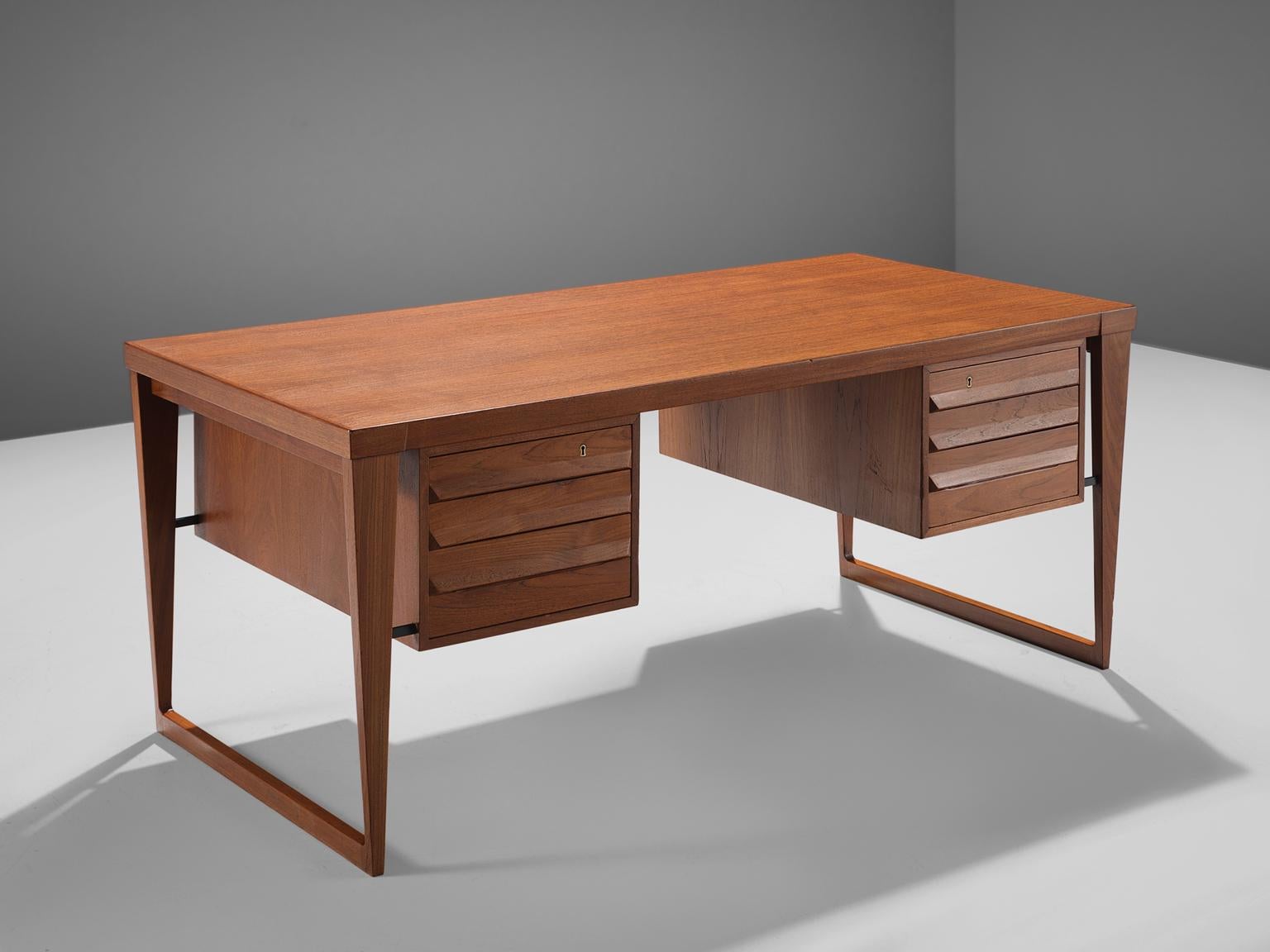 Kai Kristiansen for Feldballes Møbelfabrik, desk model 70, teak, by Denmark, design 1958, production 1960s.

This sculptural freestanding desk is executed with two solid teak sled bases and contains three drawers on both sides which can be locked.