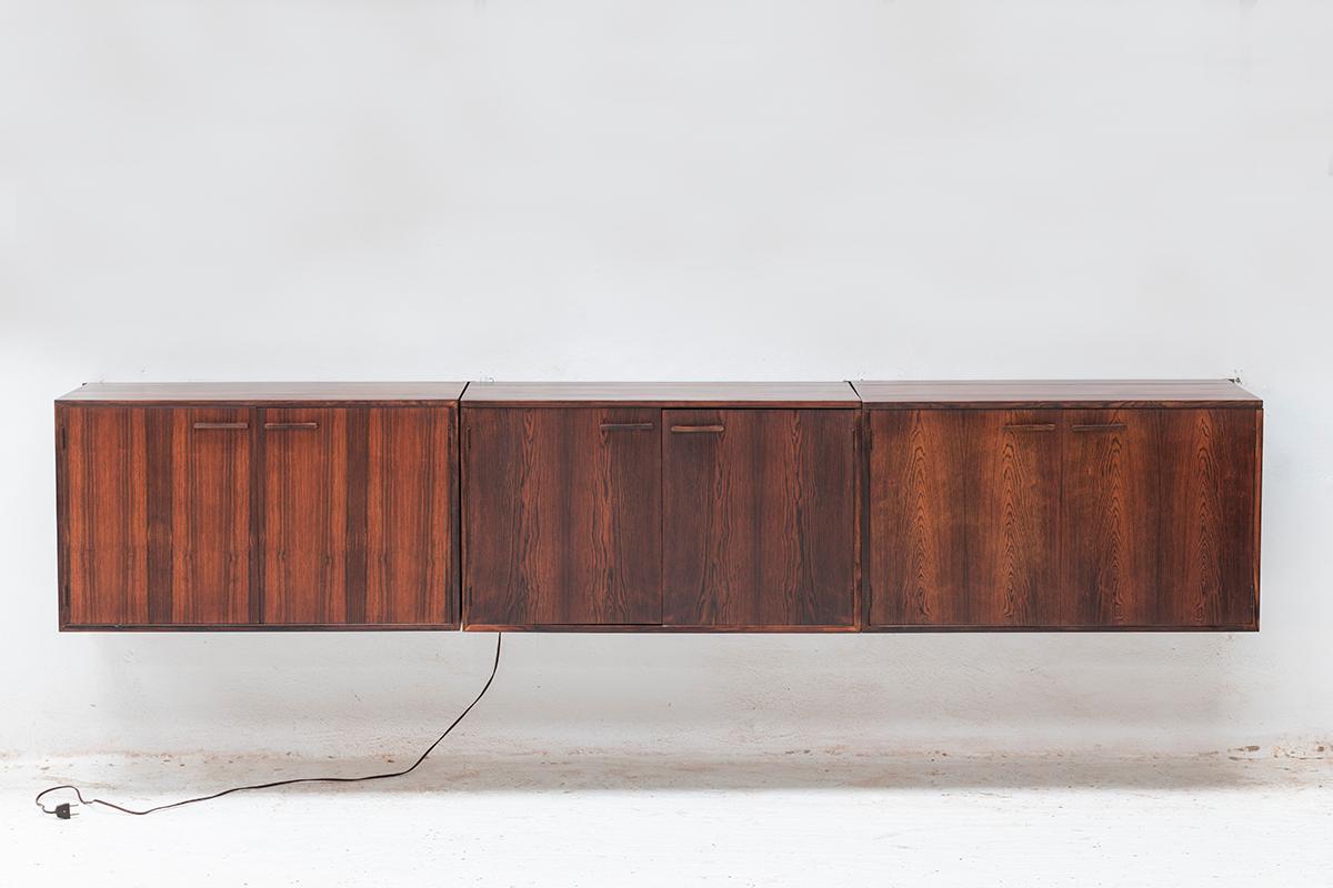 Floating sideboard by Kai Kristiansen designed in Denmark around 1960. This set features 4 metal supports and 3 big rosewood cabinets. The elements can be arranged as desired. The middle cabinet can be used as a bar cabinet for bottles and features