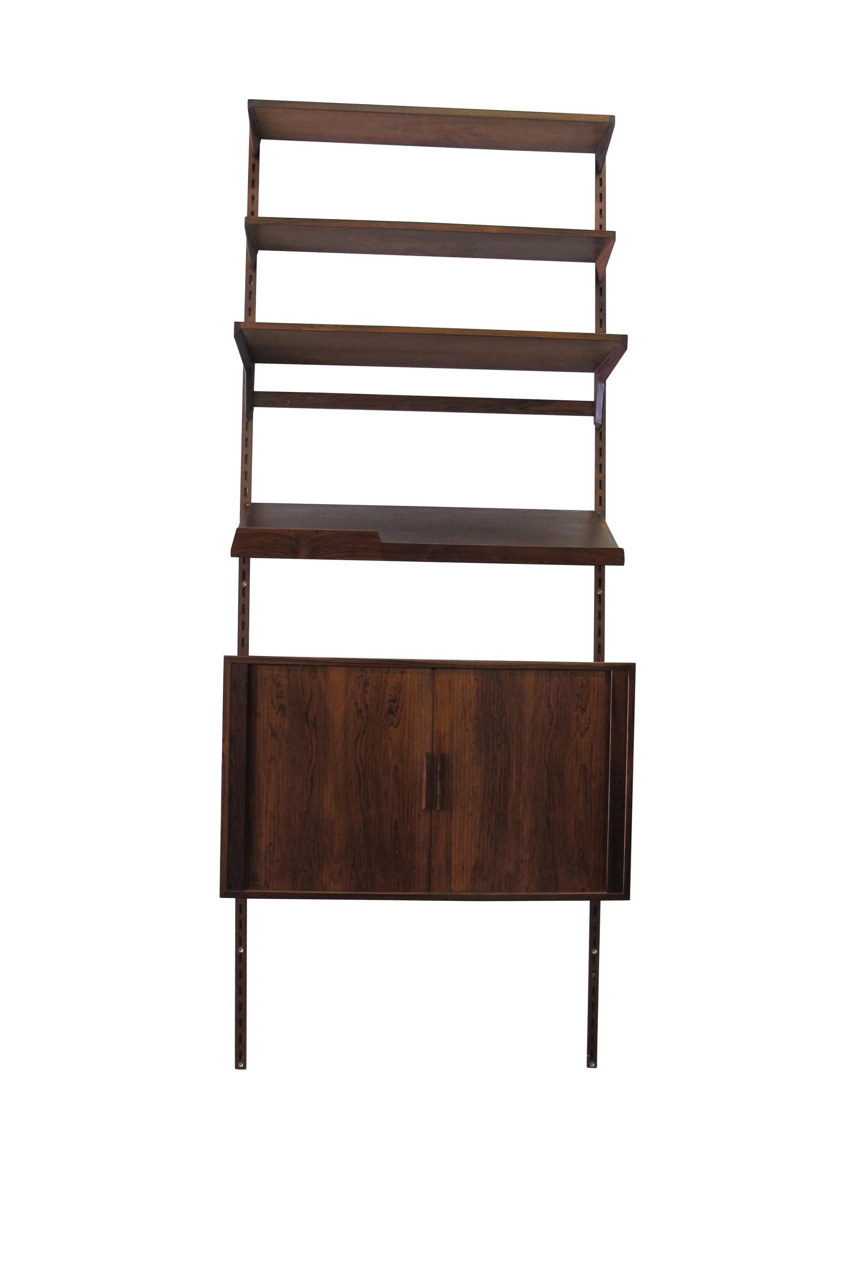 Midcentury Brazilian rosewood wall system designed by Kai Kristiansen for Feldballes Mobelfabrik Denmark. Kai Kristiansen's FM-Reolsystem is a fully interchangeable Danish wall mount shelving system customizable to any configuration. Crafted in