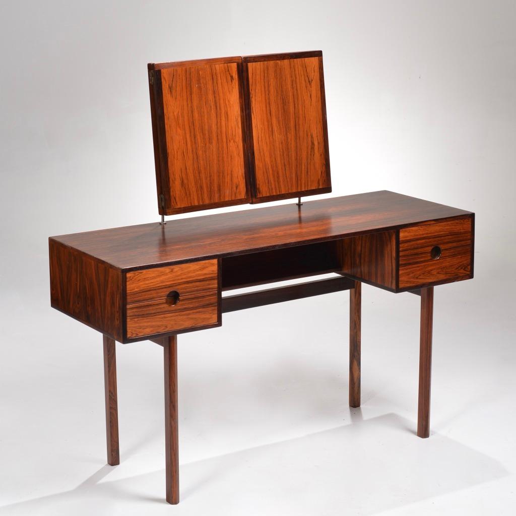 Vanity designed by Kai Kristiansen for Aksel Kjersgaard in the mid-1960s, model 40. Solid rosewood drawer fronts with striking round recessed pulls. The mirror angle adjusts by sliding the rosewood cubes up and down the mounting posts.
Great