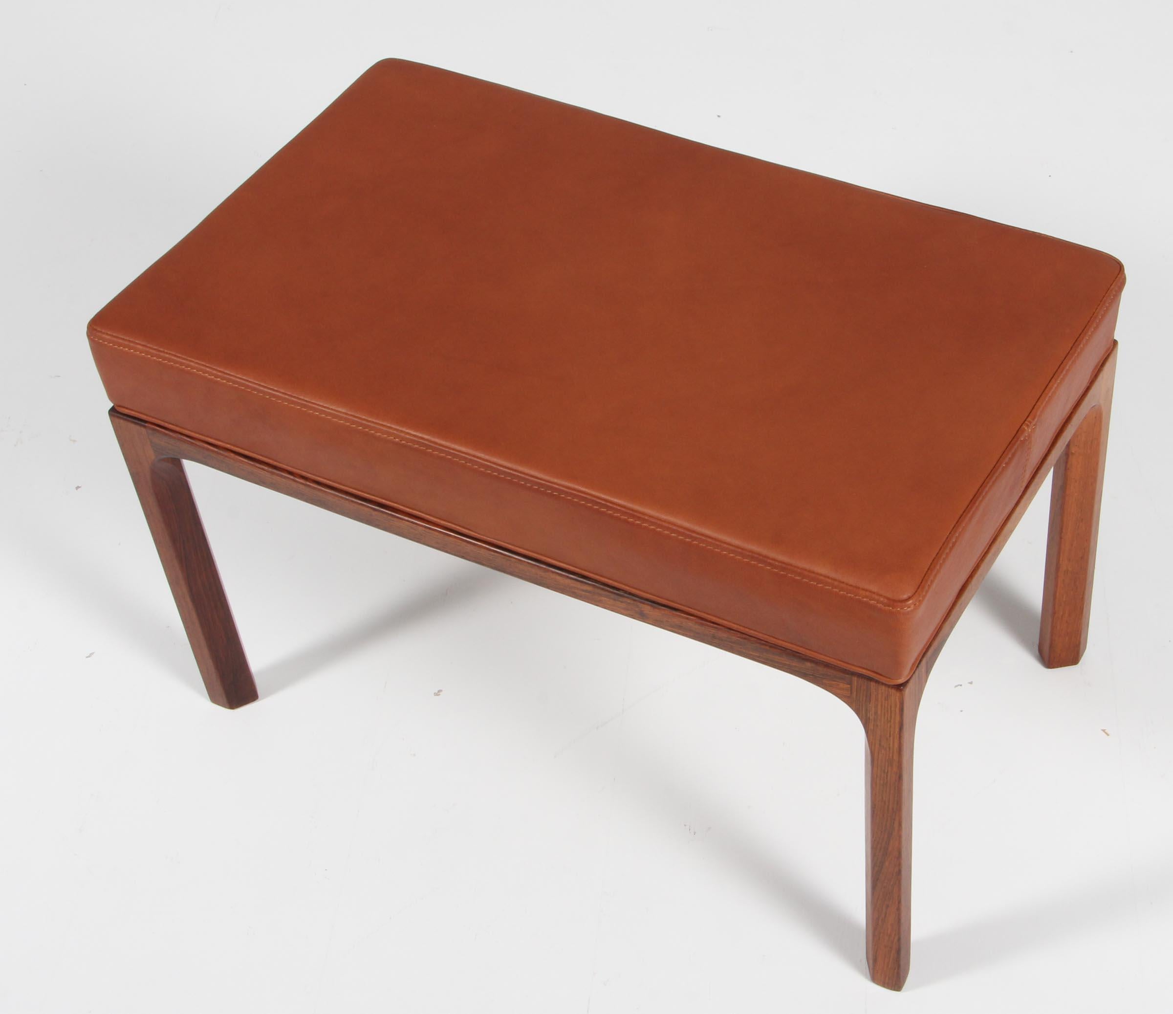 Kai Kristiansen ottoman with new upholstered seat in cognac aniline leather.

Made of solid rosewood.

Made by Aksel Kjersgaard 1960s.
