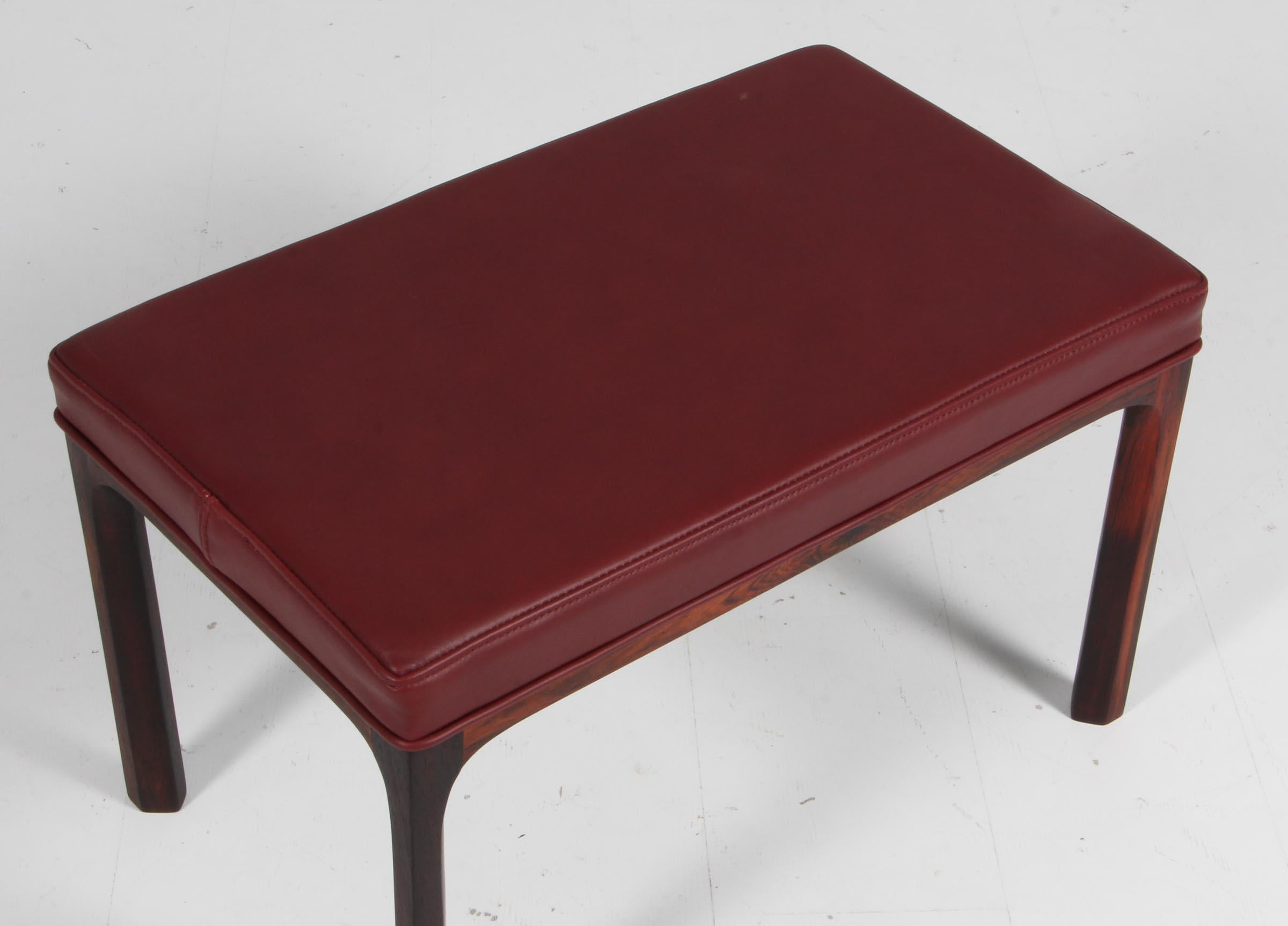 Kai Kristiansen ottoman with new upholstered seat in in Indian red elegance full grain aniline leather.

Made of solid rosewood.

Made by Aksel Kjersgaard 1960s.