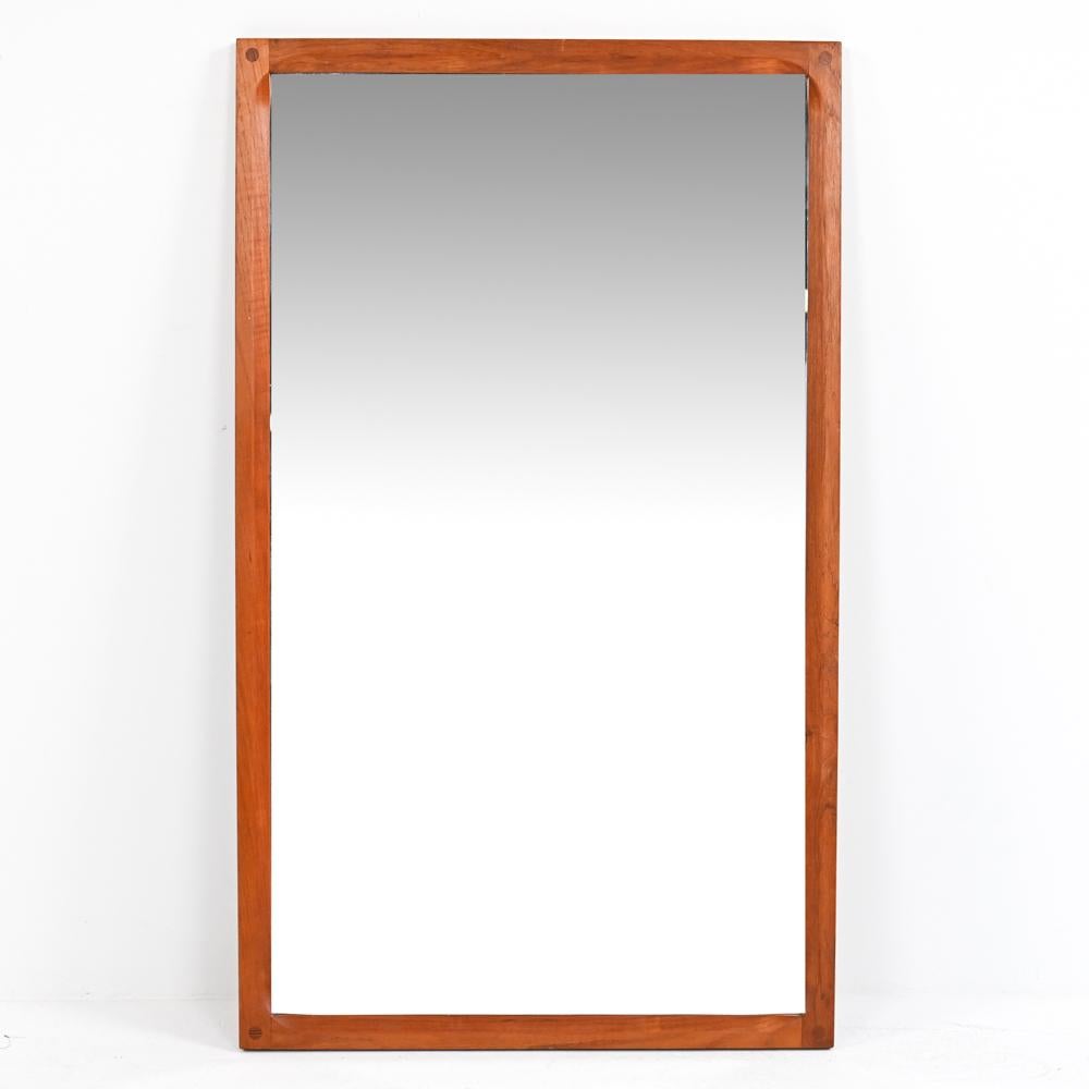 A Danish mid-century wall mirror in teak, designed by Kai Kristiansen for Aksel Kjersgaard, c. 1960's. This minimalist mirror would blend seamlessly into any interior.