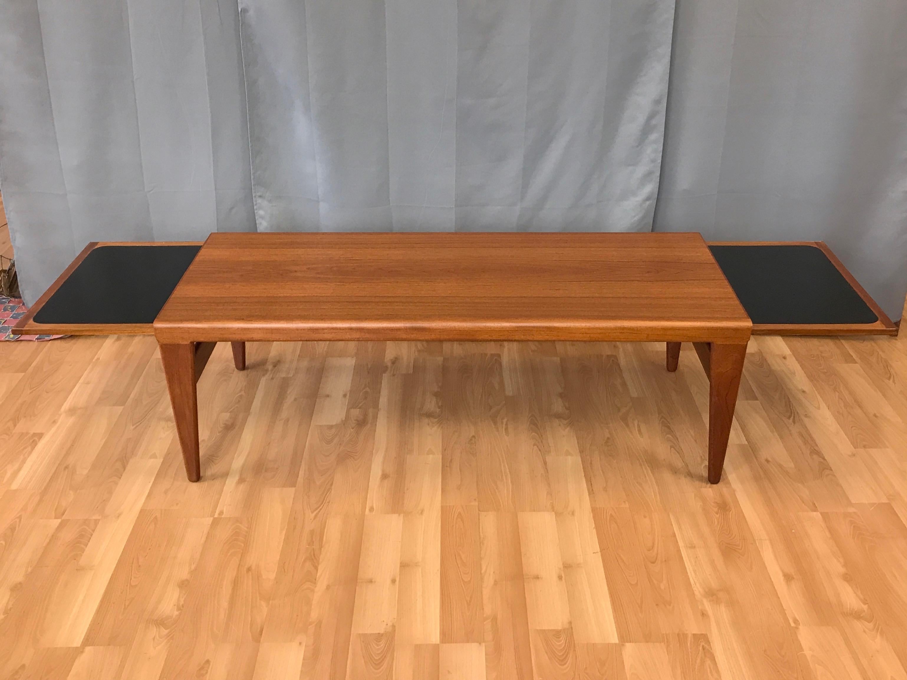 Un tavolino allungabile in teak eccezionalmente insolito di Kai Kristiansen per FM Møbler (Fedballe Møbelfabrik).

Tavolino molto elegante, lungo quasi un metro e mezzo, con gonne a cascata in teak massiccio e gambe piatte e affusolate. Le ante