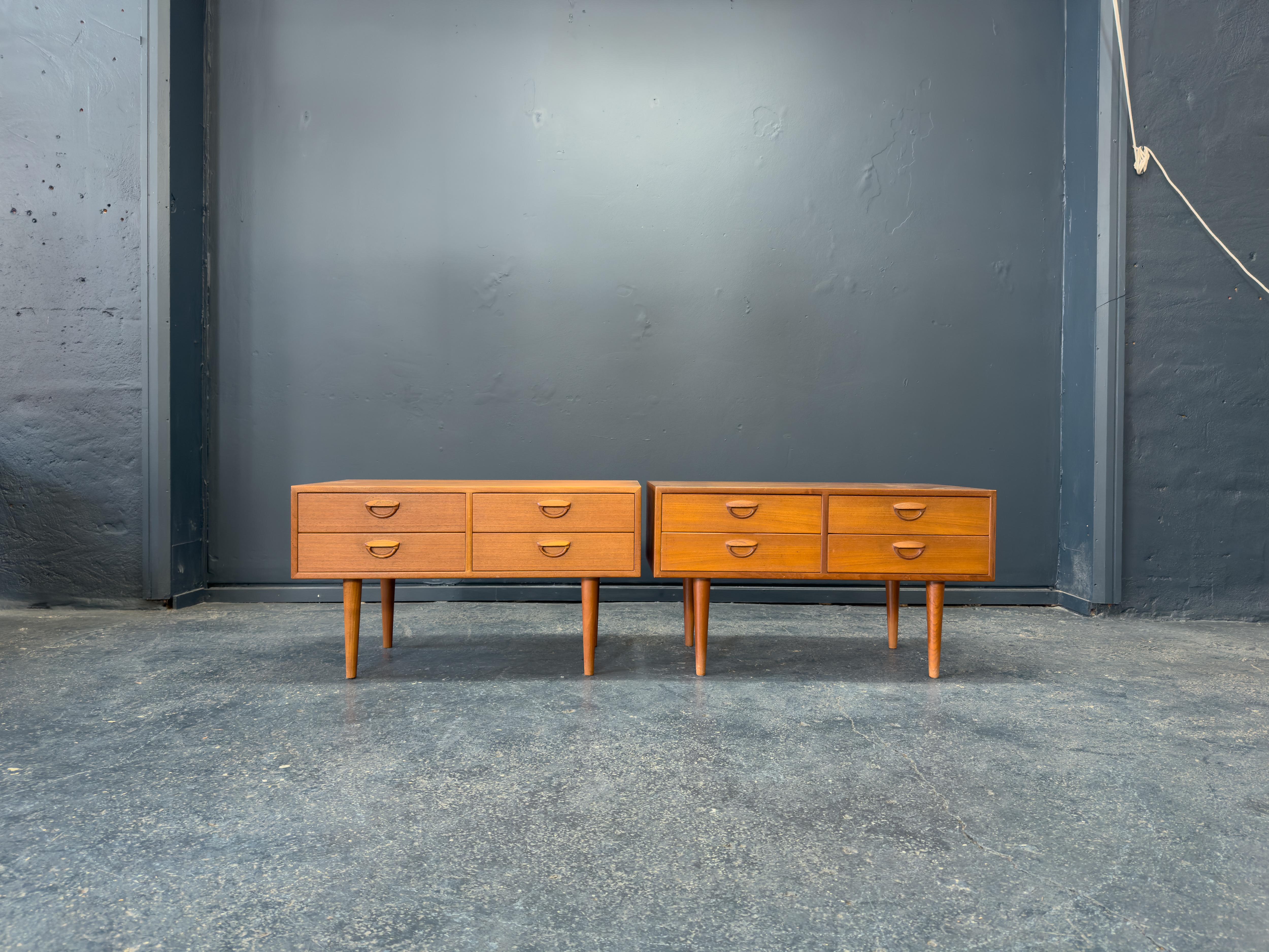 These low teak drawers by Kai Kristiansen exemplify the designer’s signature blend of functionality, refined proportions, and sculptural detailing. Crafted from richly grained teak, the pair features a compact, boxy form elevated on elegantly