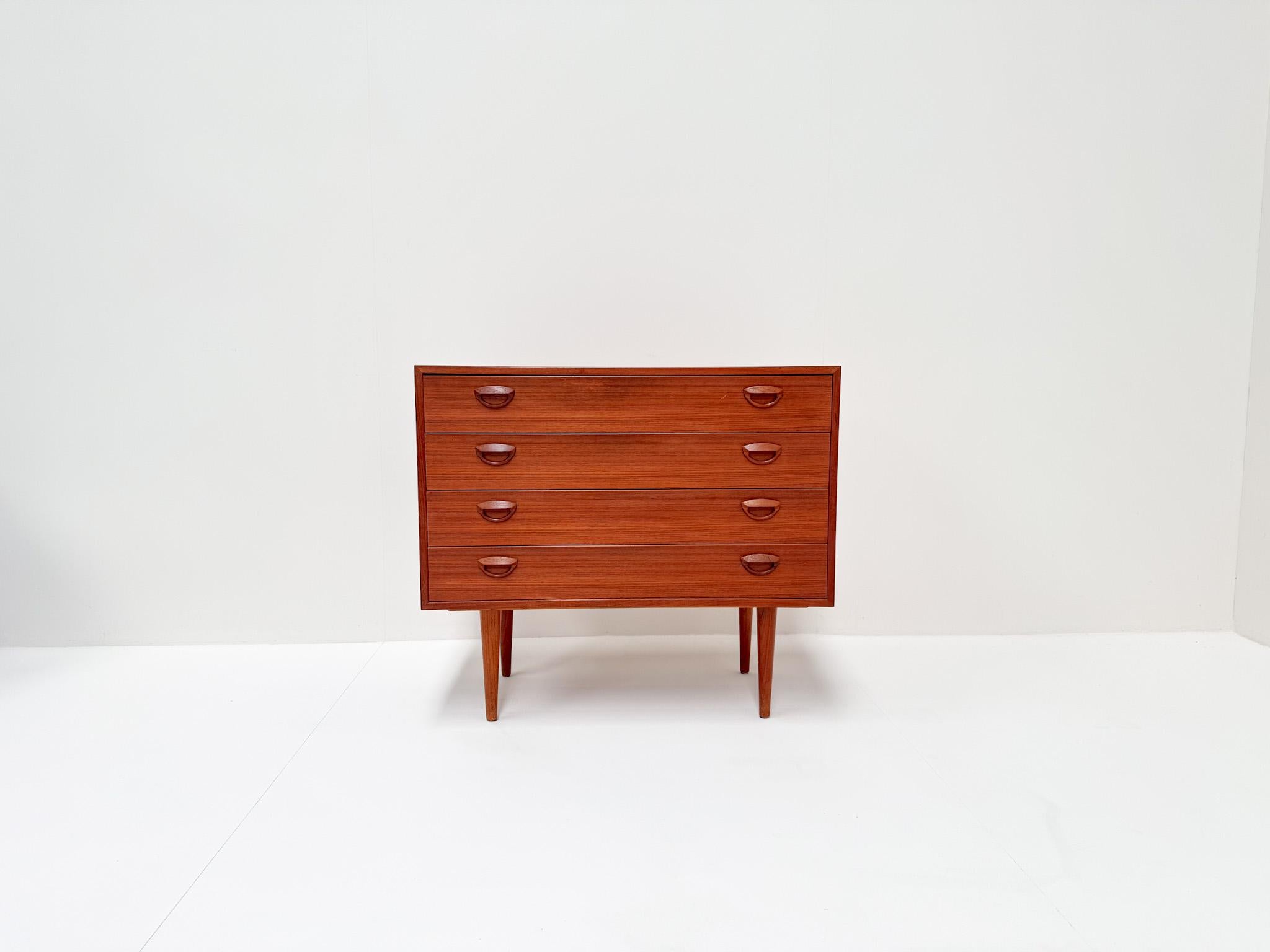 A stunning mid-century modern dresser designed by Kai Kristiansen, crafted in Denmark from rich teak wood. This elegant piece features four spacious drawers with Kristiansen’s signature sculpted handles, showcasing the timeless Scandinavian design