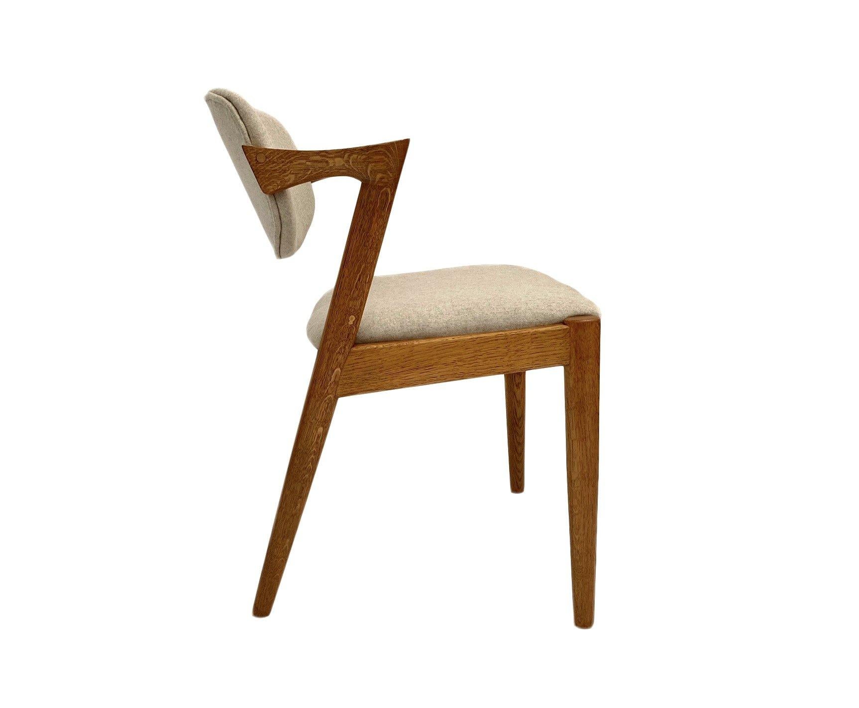 A beautiful iconic Model 42 oak and cream wool dining chair designed by Kai Kristiansen for Shous Møbelfabrik, this would make a stylish addition to any dining area.

The chair has a wide seat pad and a tilting sculptured backrest for enhanced
