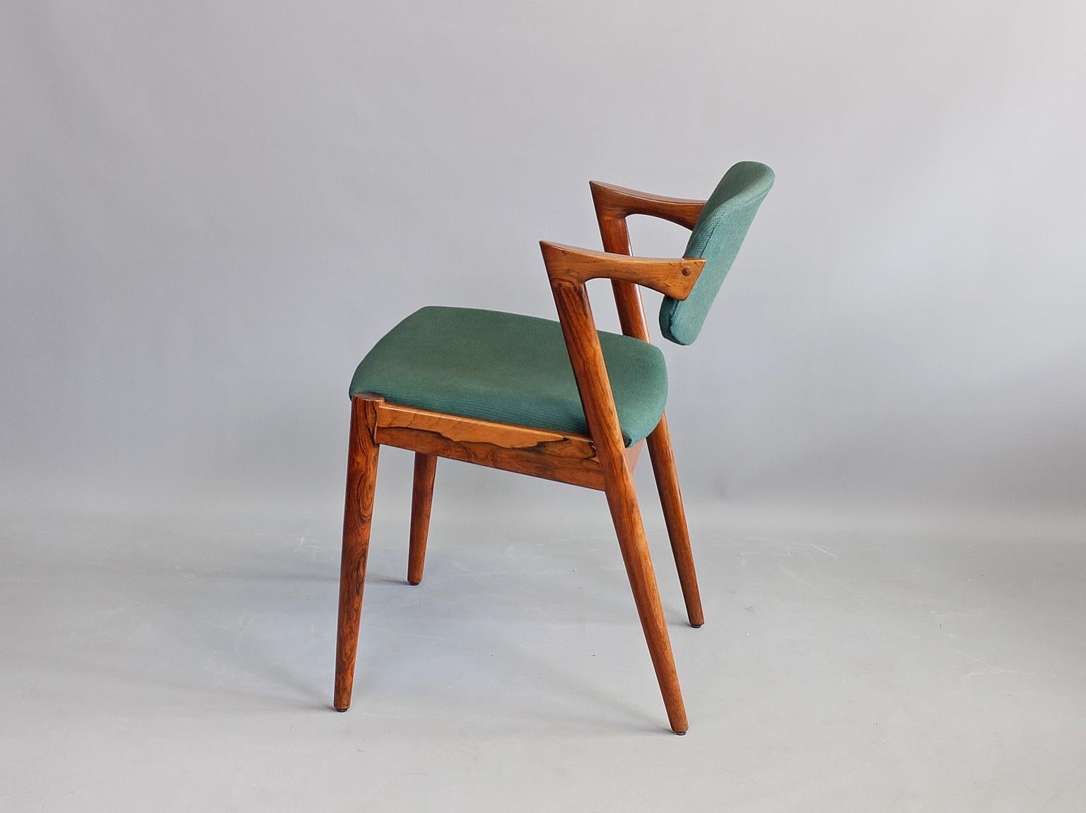 A set of four model 42 dining chairs designed by Kai Kristiansen and produced by Schou Andersen, Denmark, 1960. This set in beautifully grained Brazilian Rosewood. The frames have been fully restored and are in excellent condition. The upholstery is