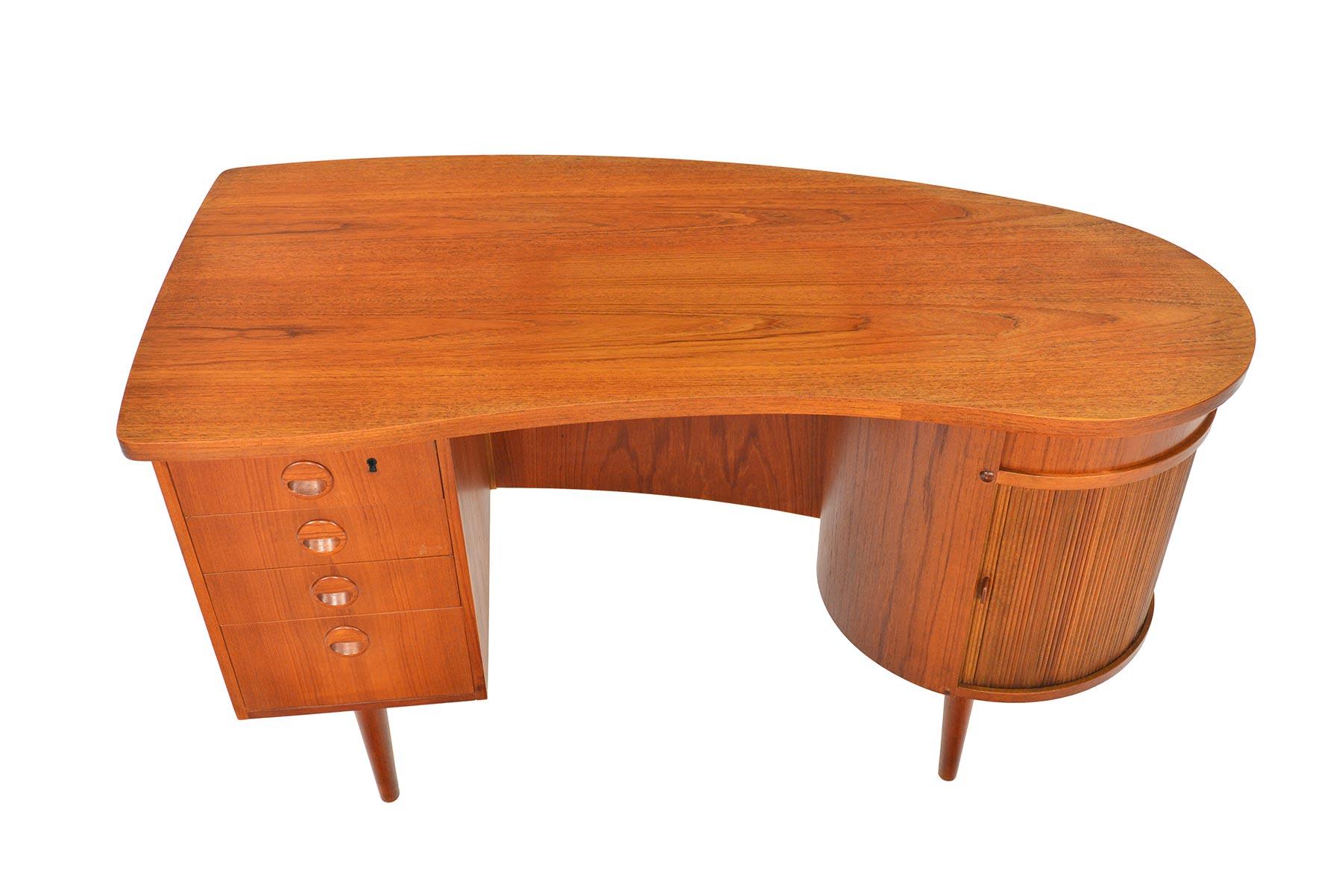 This rare Danish modern Model 54 executive desk was designed by Kai Kristiansen for Feldballes Mobelfabrik in the 1960s. Crafted in teak, this desk features a bank of four drawers with Kristiansen’s distinctive eyebrow shaped drawer pulls, bookshelf