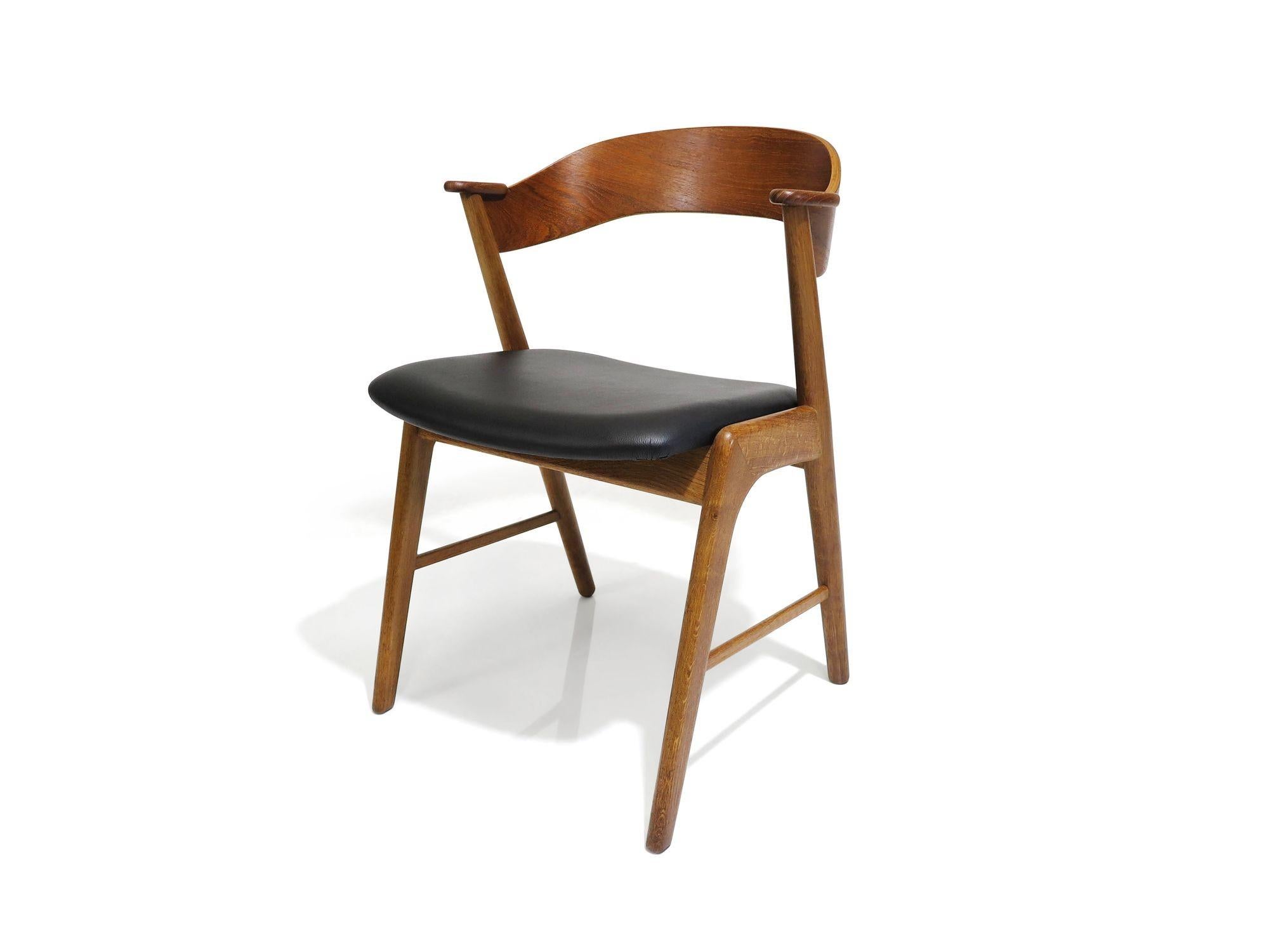 Satz von vier dänischen Esszimmerstühlen aus der Mitte des Jahrhunderts, entworfen von Kai Kristiansen, 1955, Dänemark. Die Stühle werden in Handarbeit aus massiven Eichenholzrahmen mit dramatisch geschwungener Teakholz-Rückenlehne und Kreuztraverse