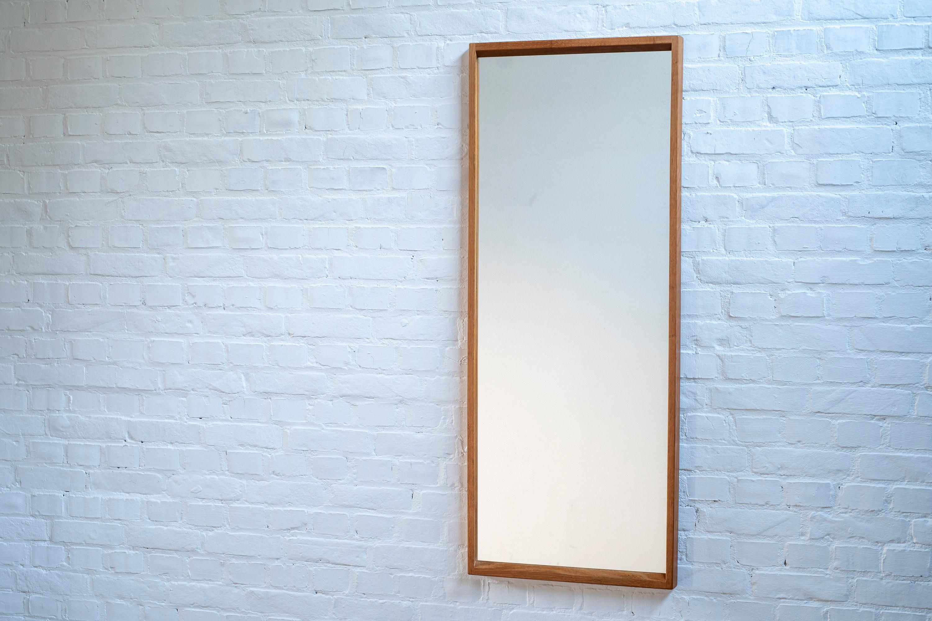 A beautiful oak mirror by designer Kai Kristiansen, produced by Aksel Kjersgaard in Odder, Denmark. Elegant design combined with wonderful craftsmanship and joinery. The mirror is in good vintage condition with normal traces of use in accordance to