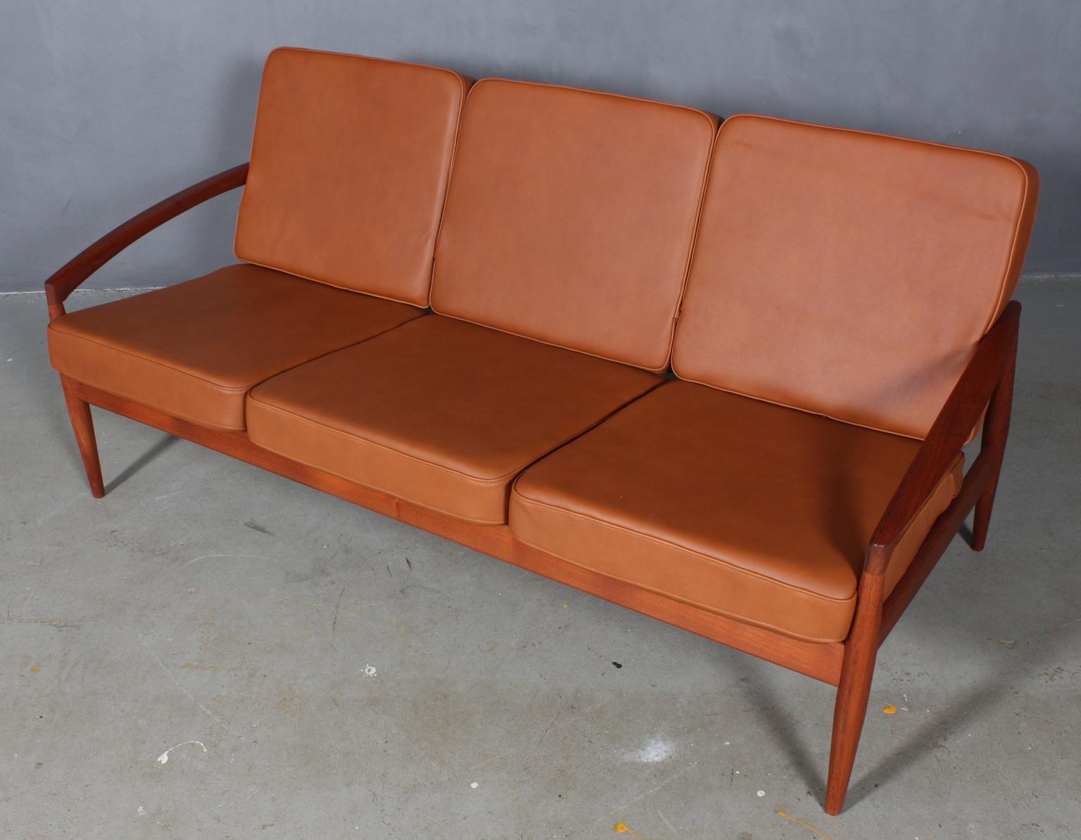 Kai Kristiansen three-seat sofa with frame of teak and organic armrests.

New upholstered with walnut elegance aniline leather.

Model paperknife, made by Magnus Olsen.