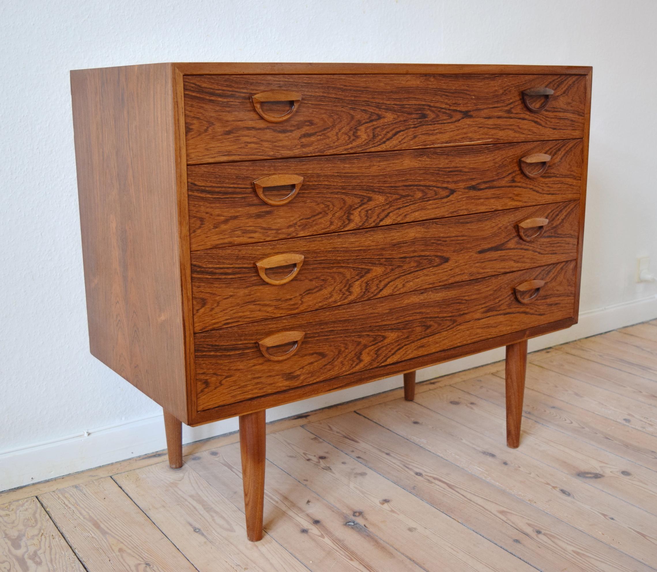 Danish rosewood chest designed by Kai Kristiansen and manufactured by Feldballes Møbelfabrik in the 1960s. It features Kai Kristiansen's signature recessed drawer pulls and sits on turned and tapered legs. Labelled by manufacturer on rear.
