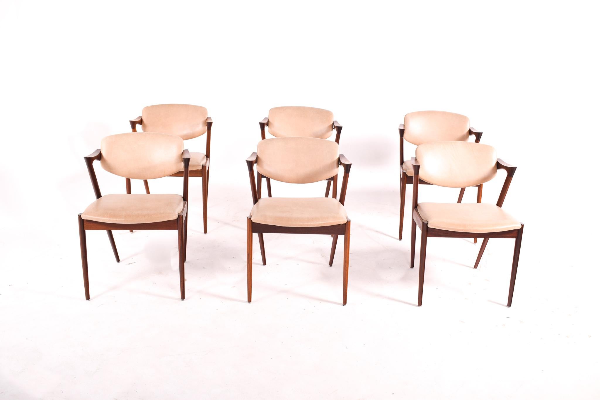 Set of 6 dining chairs model 42 in rosewood. Design by Kai Kristiansen in 1963. The tilting backs and carved armrests are designed for comfort as well as beauty. Made by V. Schou Andersen in Denmark.