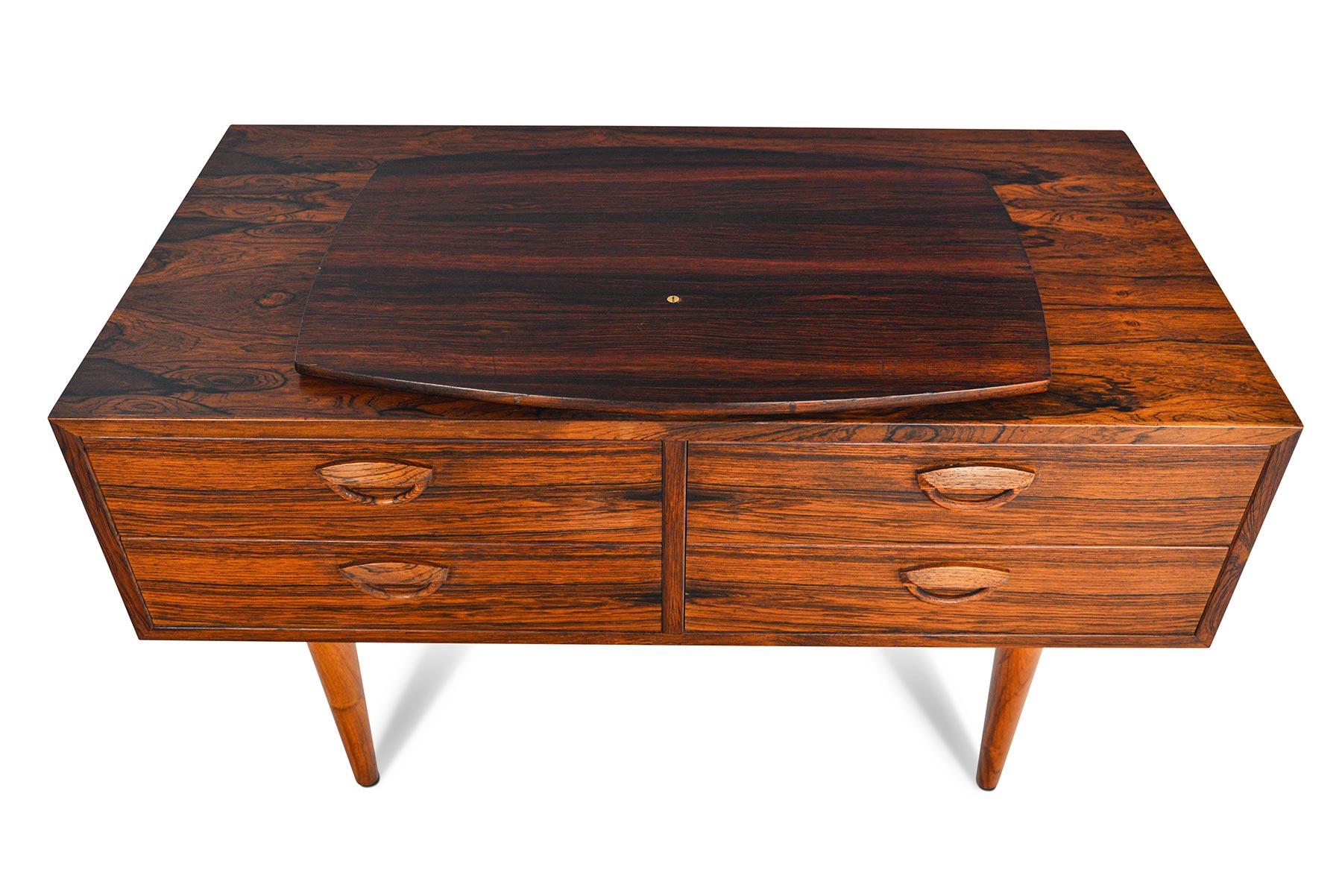This Danish modern chest was designed as Model 50 in 1958 by Kai Kristiansen for Feldballes Møbelfabrik. The chest features a swivel rosewood lazy, Susan that offer 360° of movement. The only thing more striking than the designer’s signature pulls