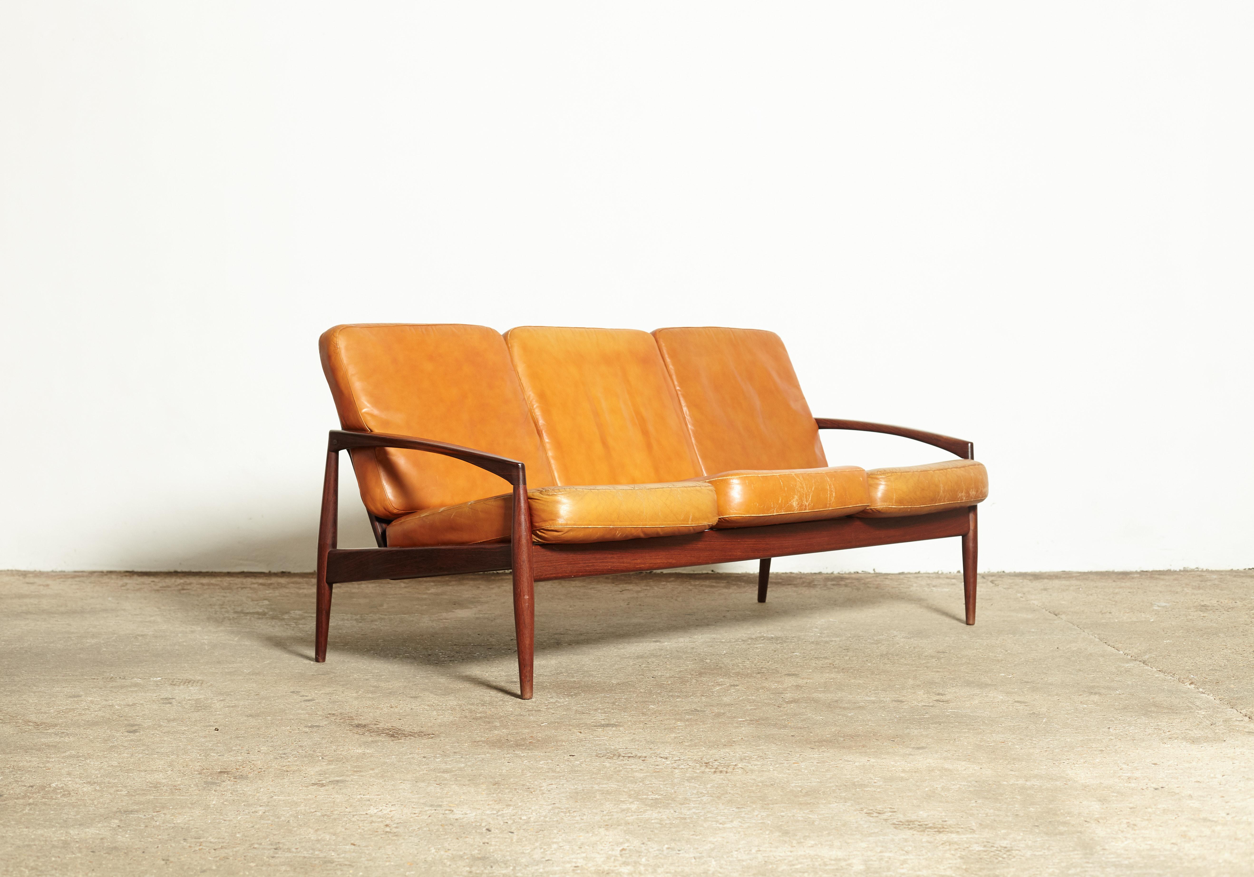 A superb rosewood Kai Kristiansen paper knife sofa, produced by Magnus Olesen, Denmark, 1960s. Rosewood frame in good condition and original patinated cognac leather cushions. Stamped with makers mark. The cushions show some wear but are loose so