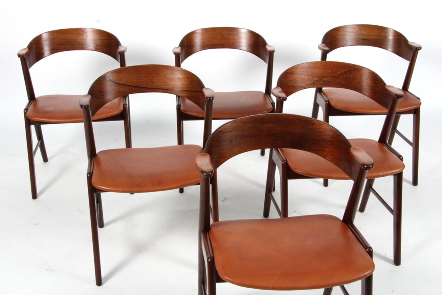 Kai Kristiansen for KS Møbler, set of 6 dining chairs, rosewood, fabric, Denmark, 1950s. 

The chairs show beautiful and well designed lines and joints. The curved back and armrests are mounted on the oblique rear legs, which provides an open,