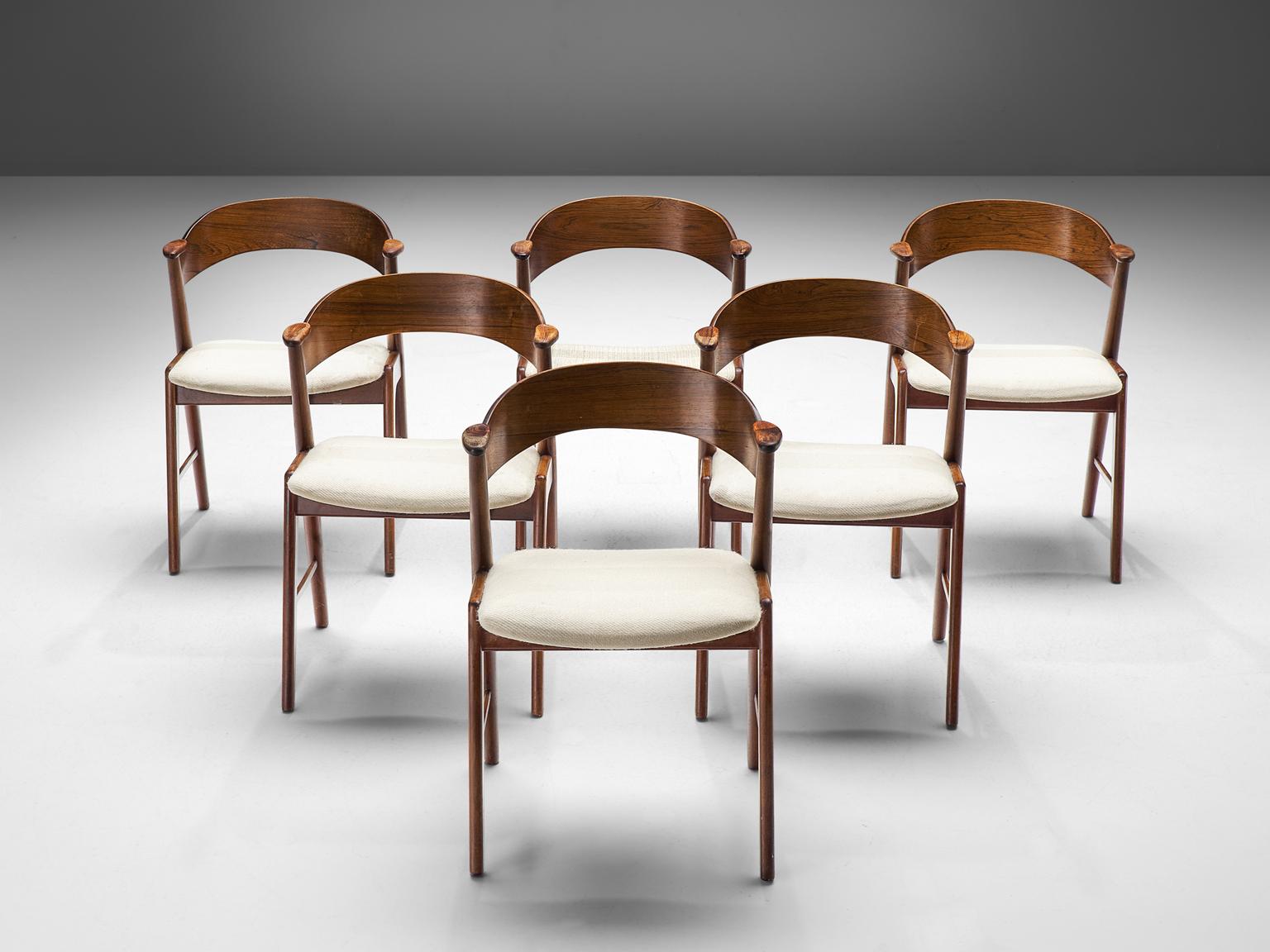 Kai Kristiansen for KS Møbler, set of 18 dining chairs, rosewood, fabric, Denmark 1950s. 

The chairs show beautiful and well designed lines and joints. The curved back and armrests are mounted on the oblique rear legs, which provides an open,