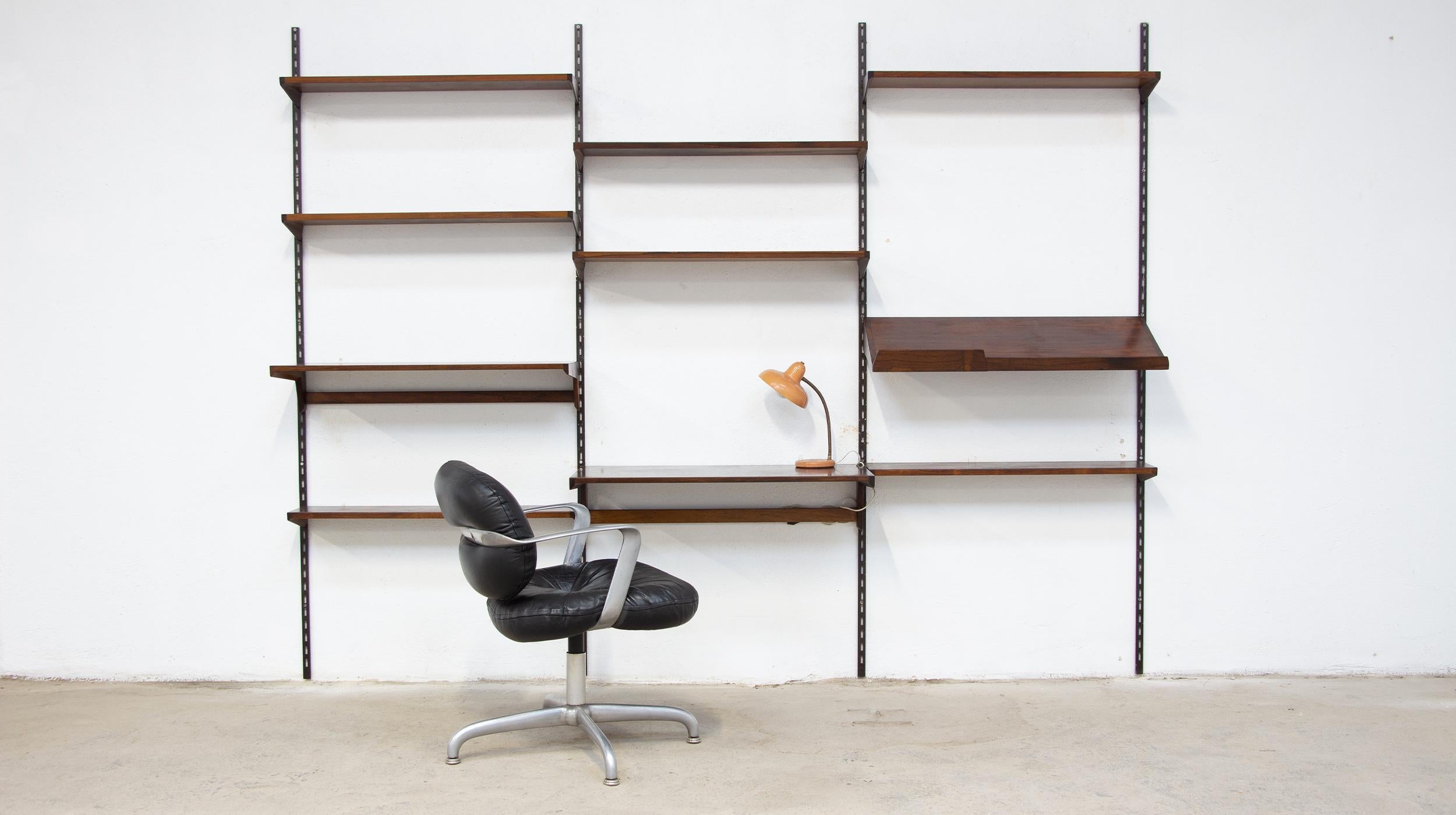 Danish bookshelf by designer Kai Kristiansen in Rio rosewood, FM furniture edition. Circa 1960.

A beautiful set of 9 airplane wing-shaped shelves in solid Rio rosewood and veneers, which hang without tools from dark brown metal uprights.
A