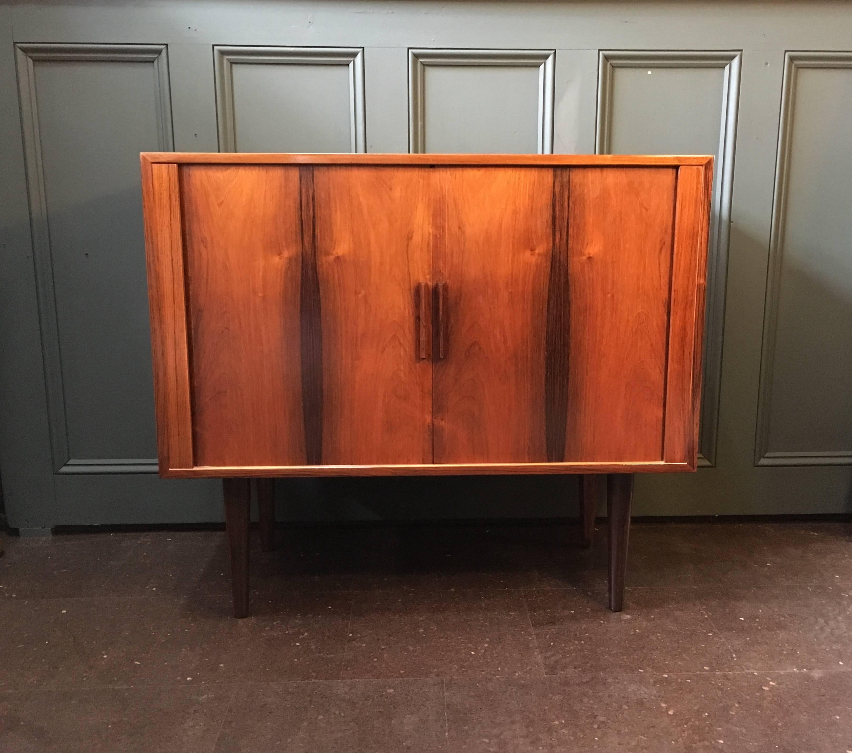 A great mid-size tambour door sideboard by Kai Kristiansen, Denmark, circa 1960.
Adjustable interior shelf with small vinyl rack. Beautifully grained wood. Surface has been refinished.