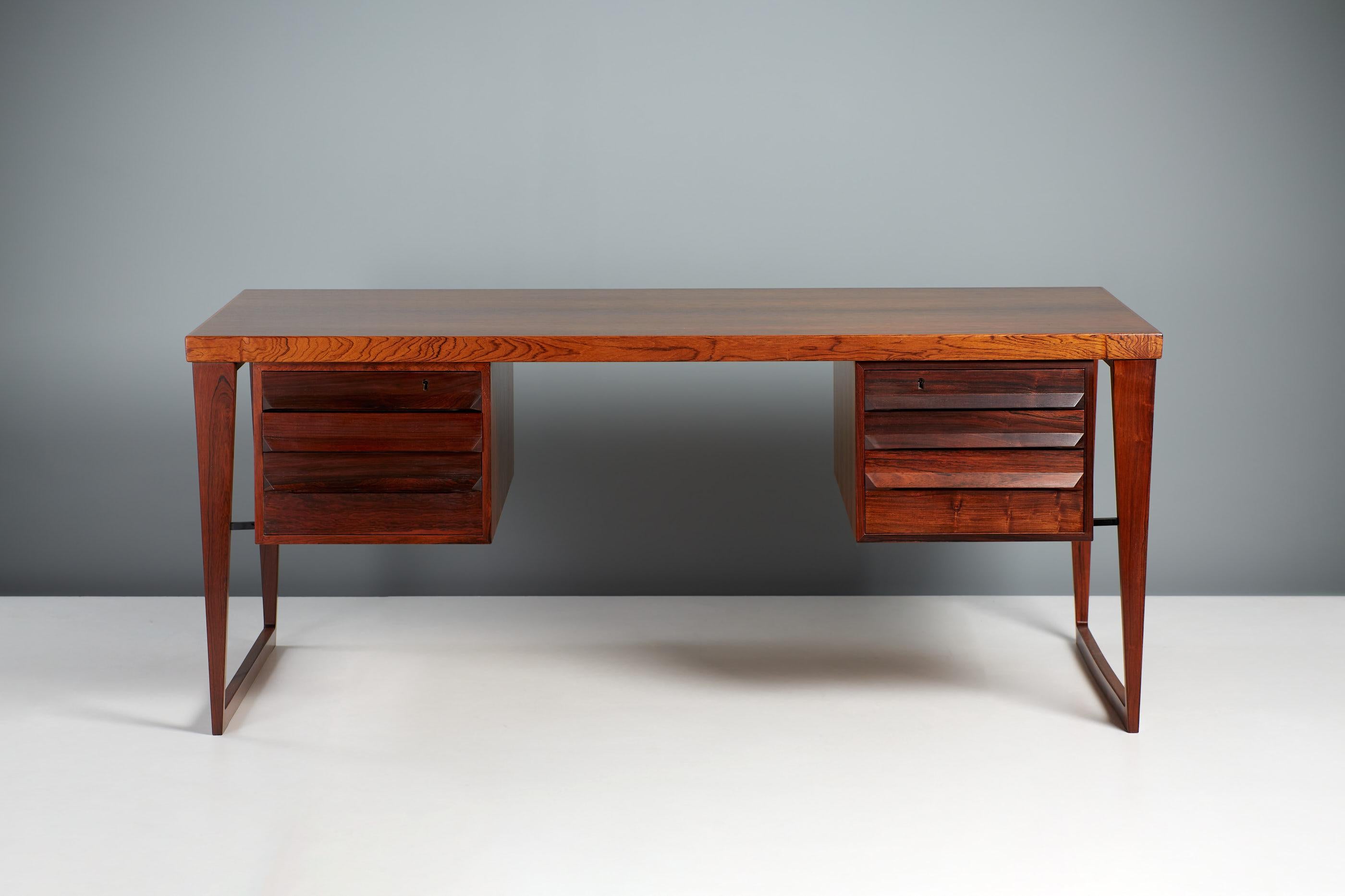 Kai Kristiansen Model 30 Desk

This iconic desk from Danish master Kai Kristiansen features elegant sled legs with 2 drawer units hung on either side. The units have drawers to the front and cupboards to the rear. It was produced in highly figured
