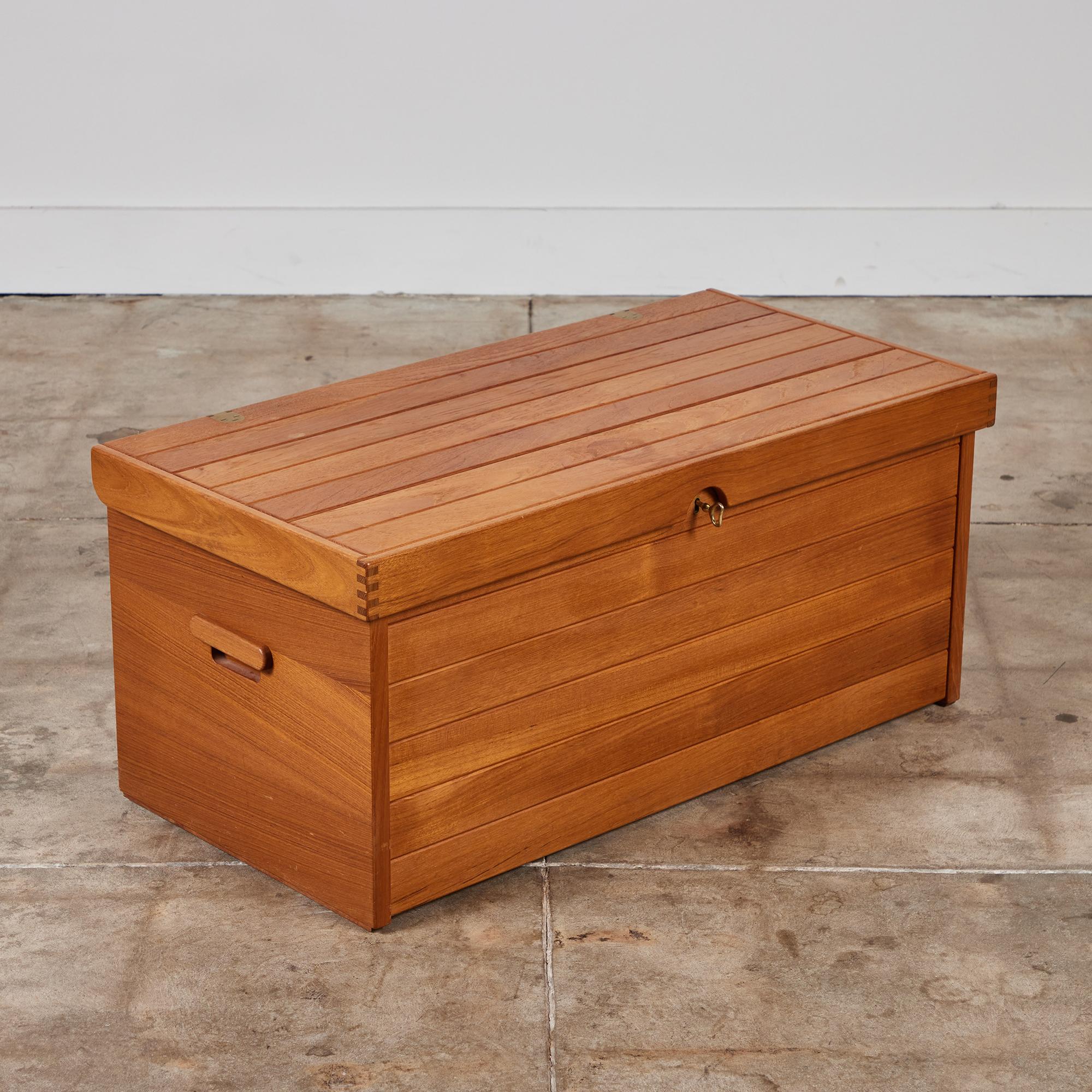 Storage trunk by Kai Kristiansen for Aksel Kjersgaard, c.1960s, Denmark. The teak chest features a brass hinged lid and brass lock with key. The inside of the chest showcases a large open cavity for storage and a small tray that rests along the top