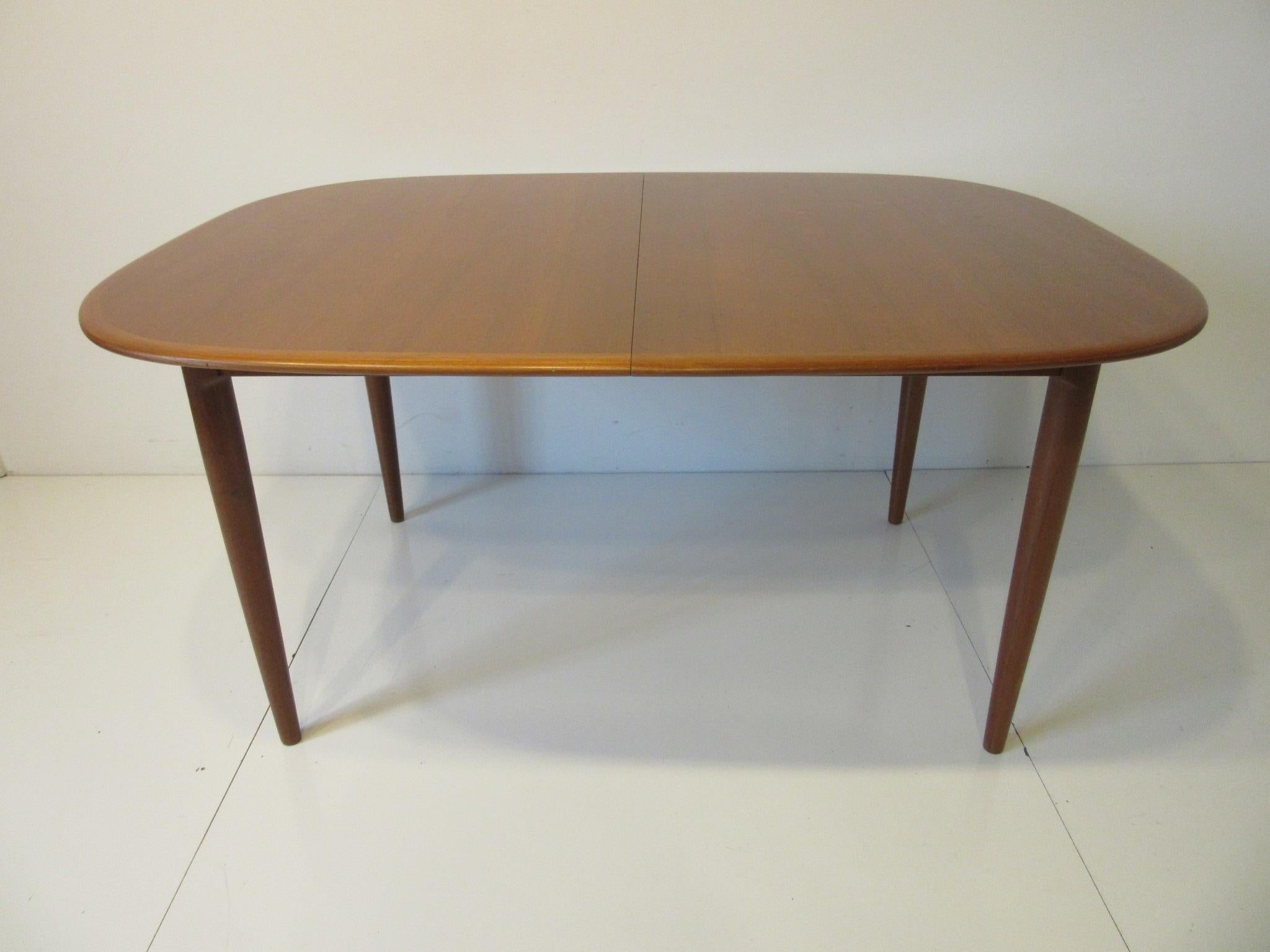 A well constructed and designed medium toned teak wood dining table with two 18.75
